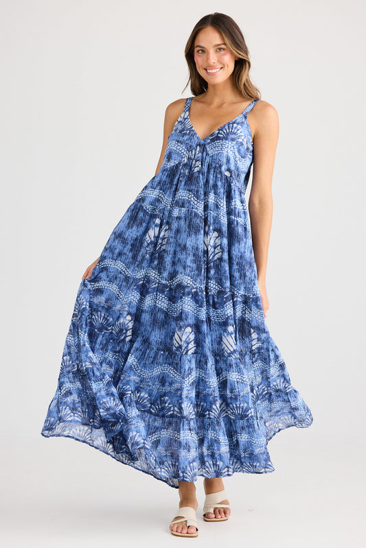 Woman wearing a blue tie-dye dress on a white background
