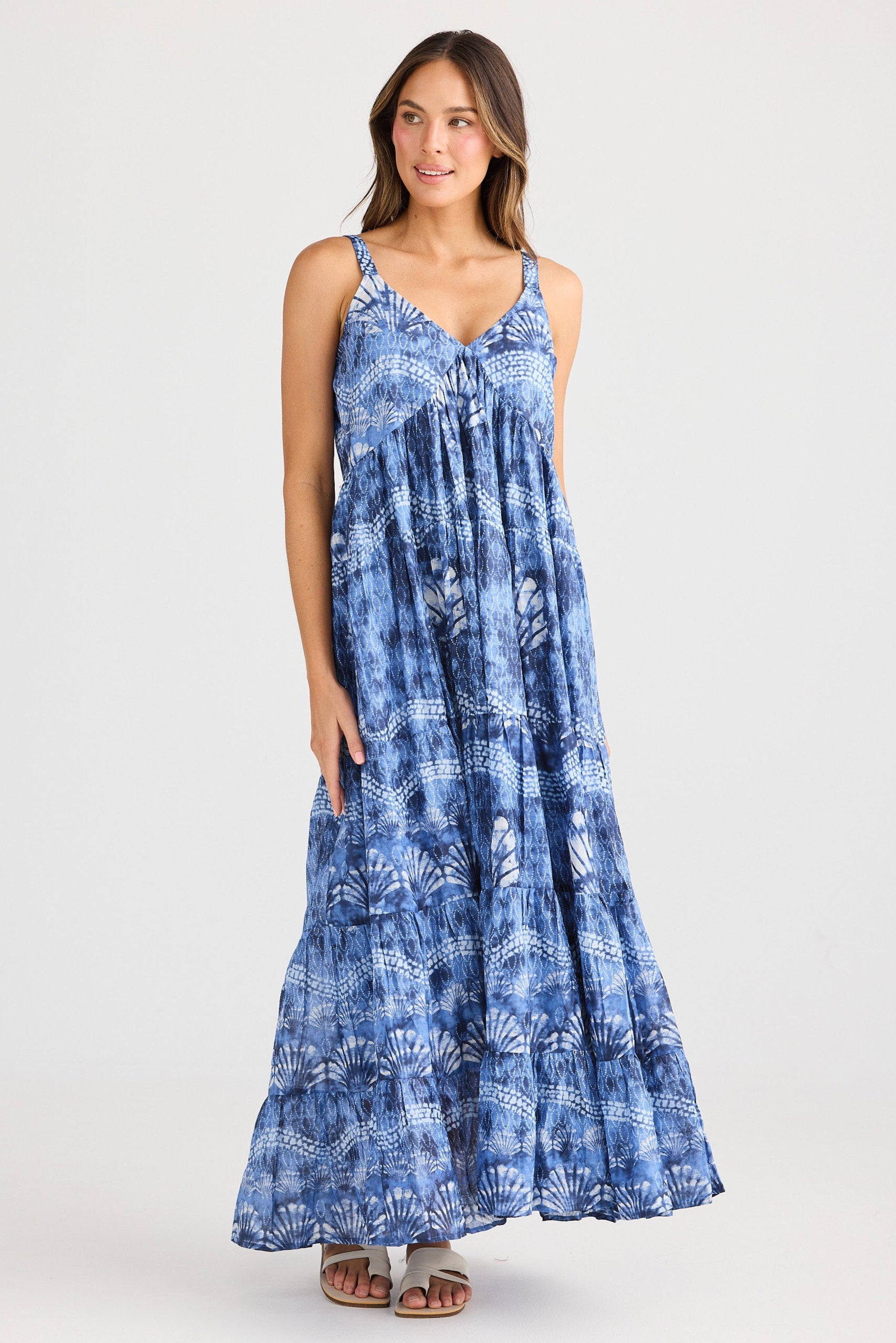 Woman wearing a blue patterned dress on a white background