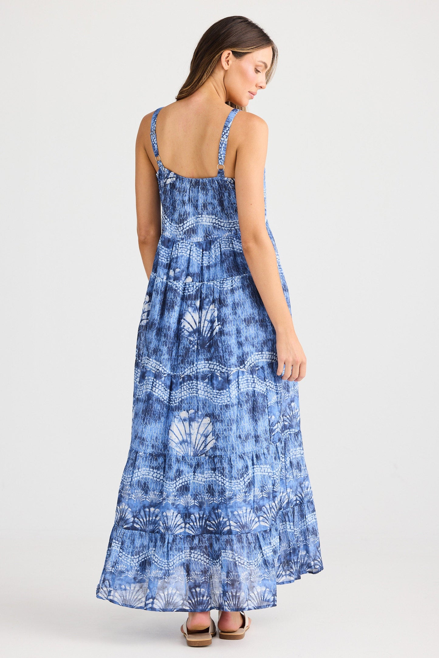 Woman wearing a blue patterned dress on a white background