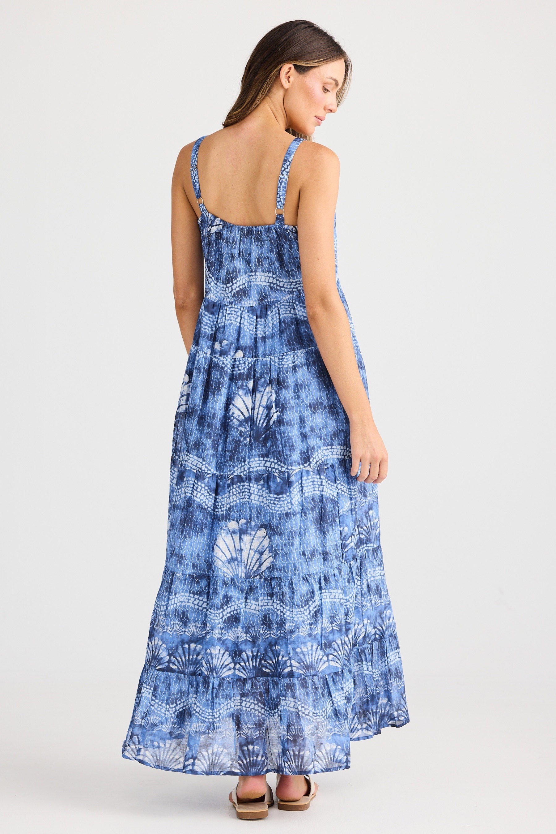 Woman wearing a blue patterned dress on a white background