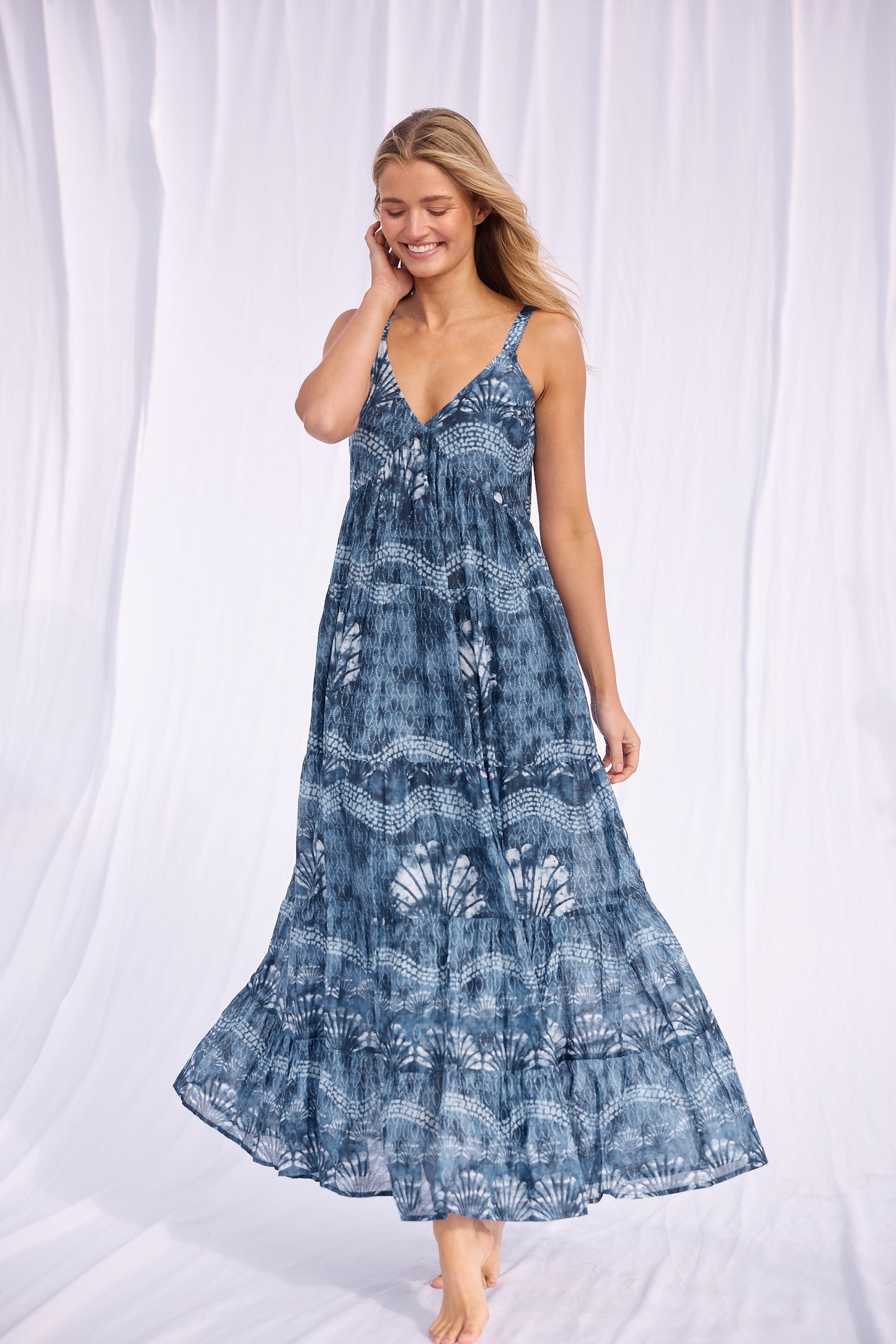 Woman wearing a blue patterned dress against a white background