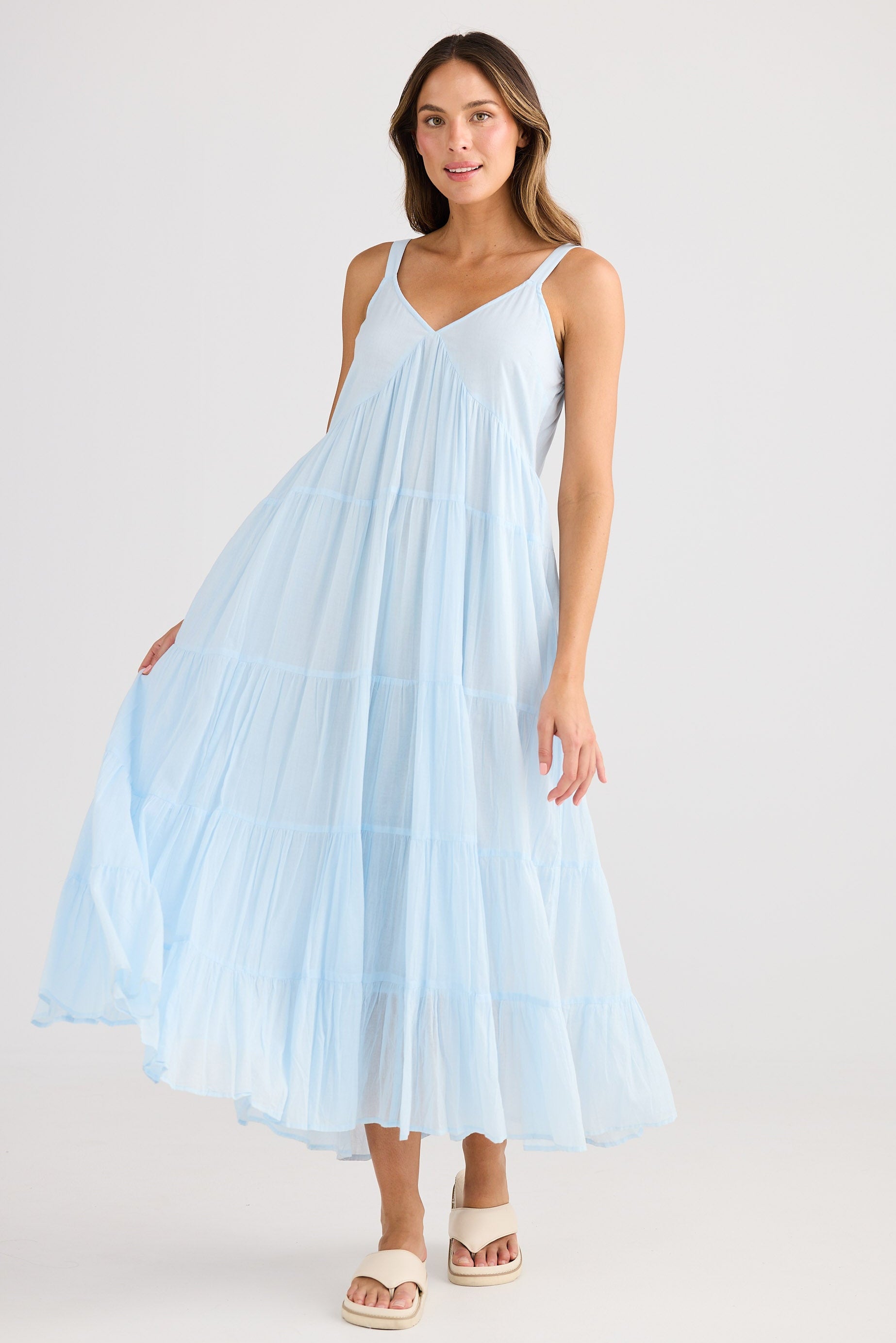 Woman wearing a light blue dress against a white background