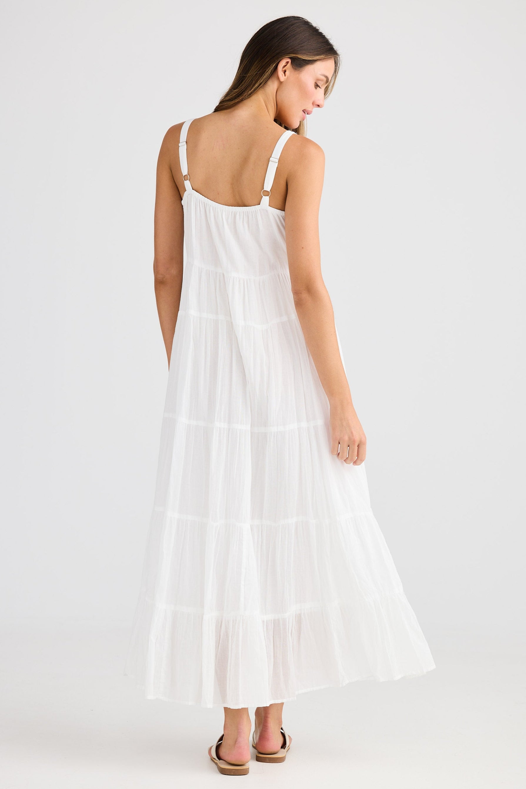 Woman wearing a white dress on a plain background