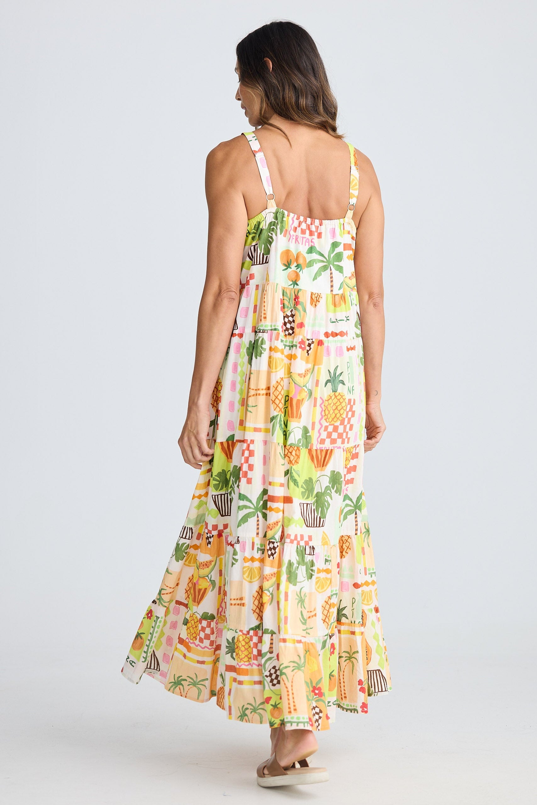 Woman wearing a colorful pineapple patterned dress on a white background
