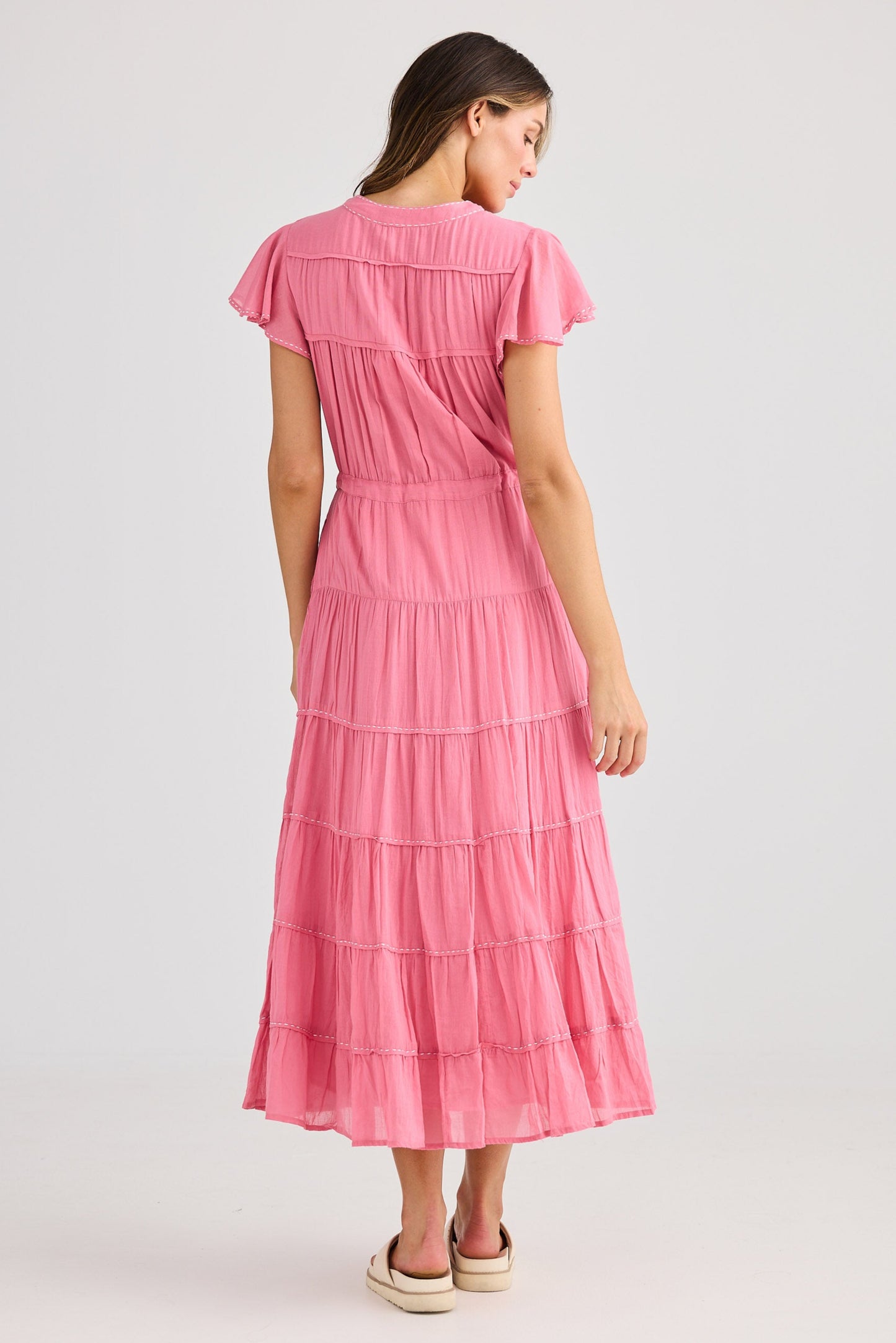 Woman wearing a pink dress on a light gray background