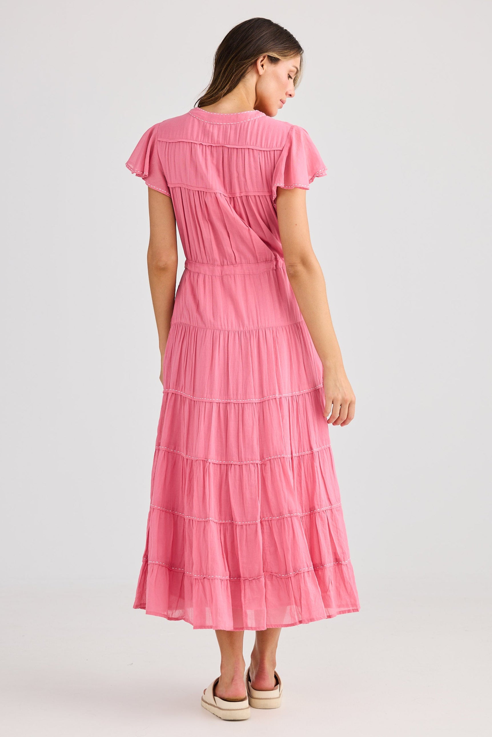 Woman wearing a pink dress on a light gray background