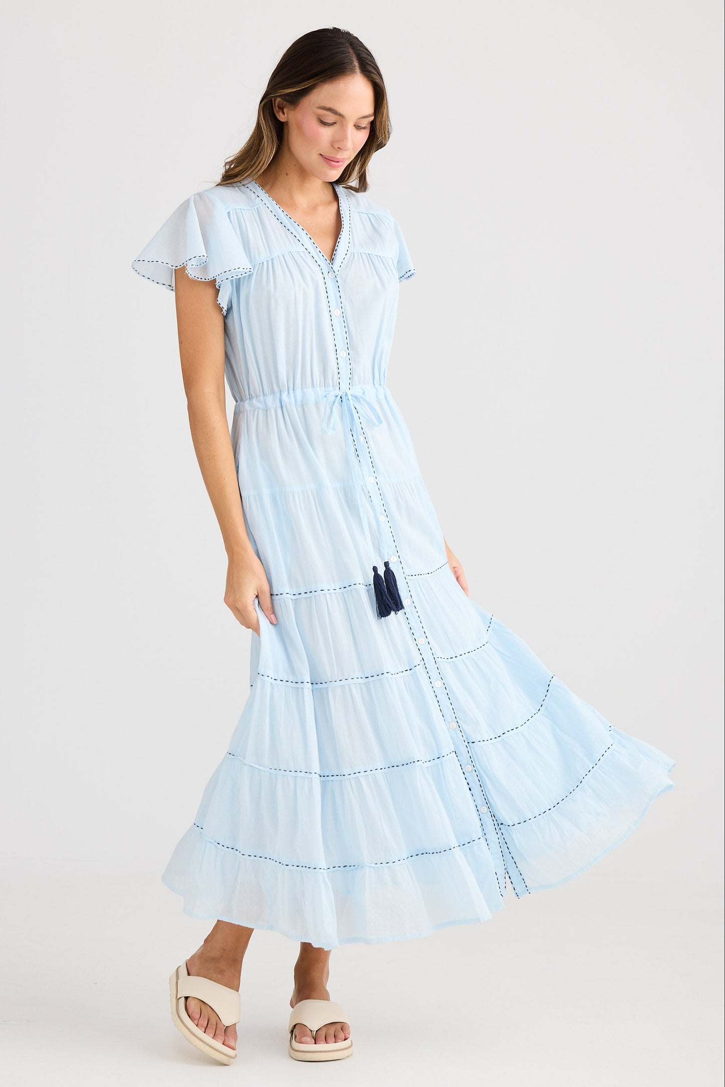 Woman wearing a light blue dress with a white background