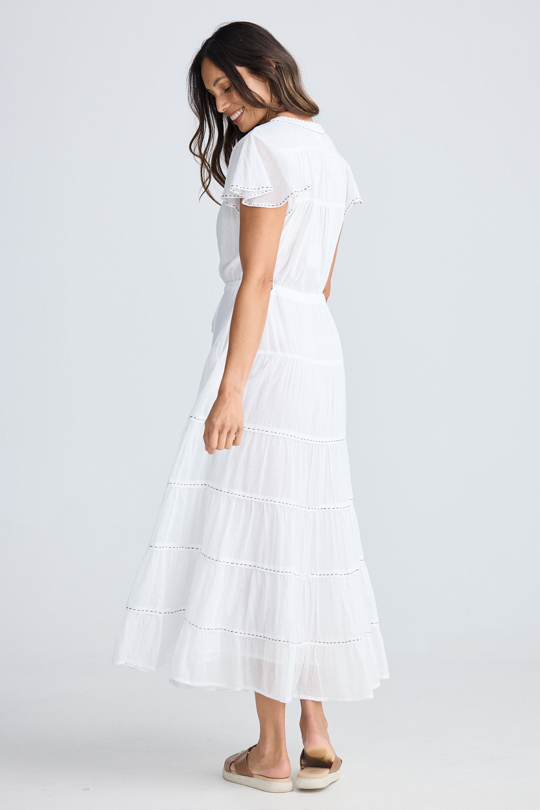 Woman wearing a white dress on a plain background