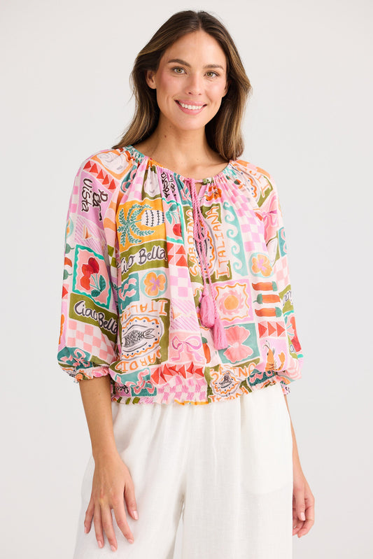 Woman wearing a colorful patterned blouse with a white background