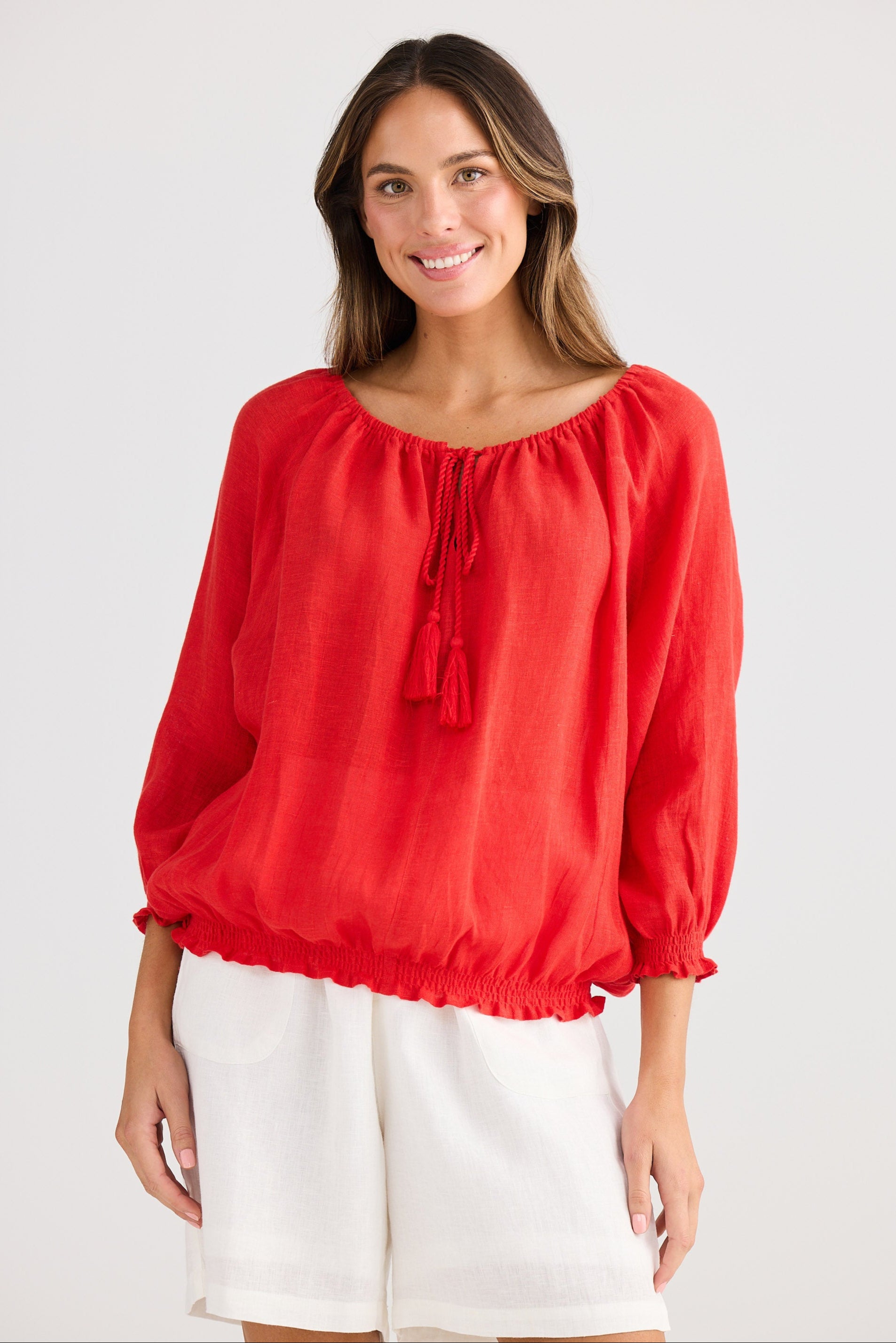 Woman wearing a red blouse with balloon sleeves on a white background