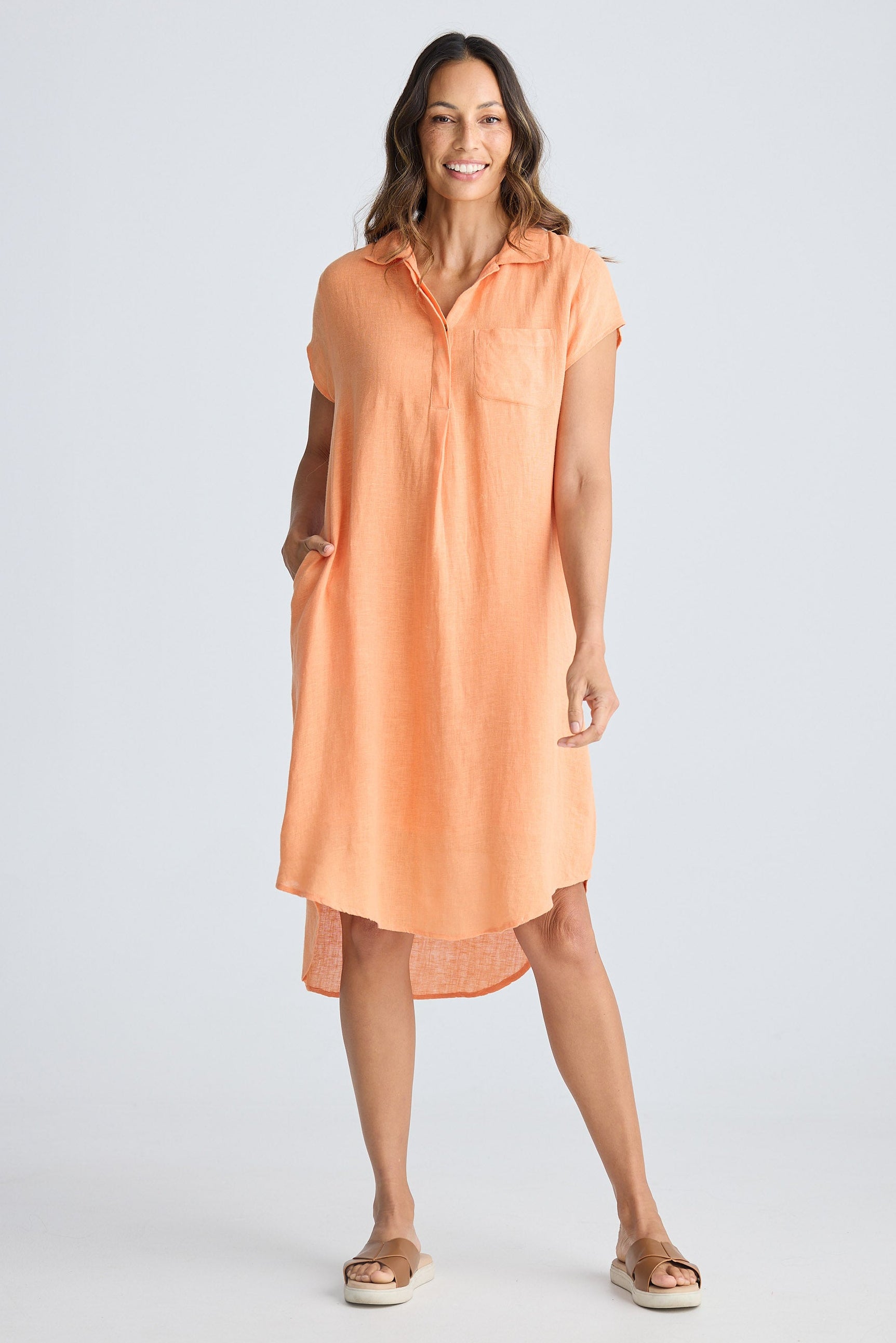 Woman wearing a peach-colored dress on a white background