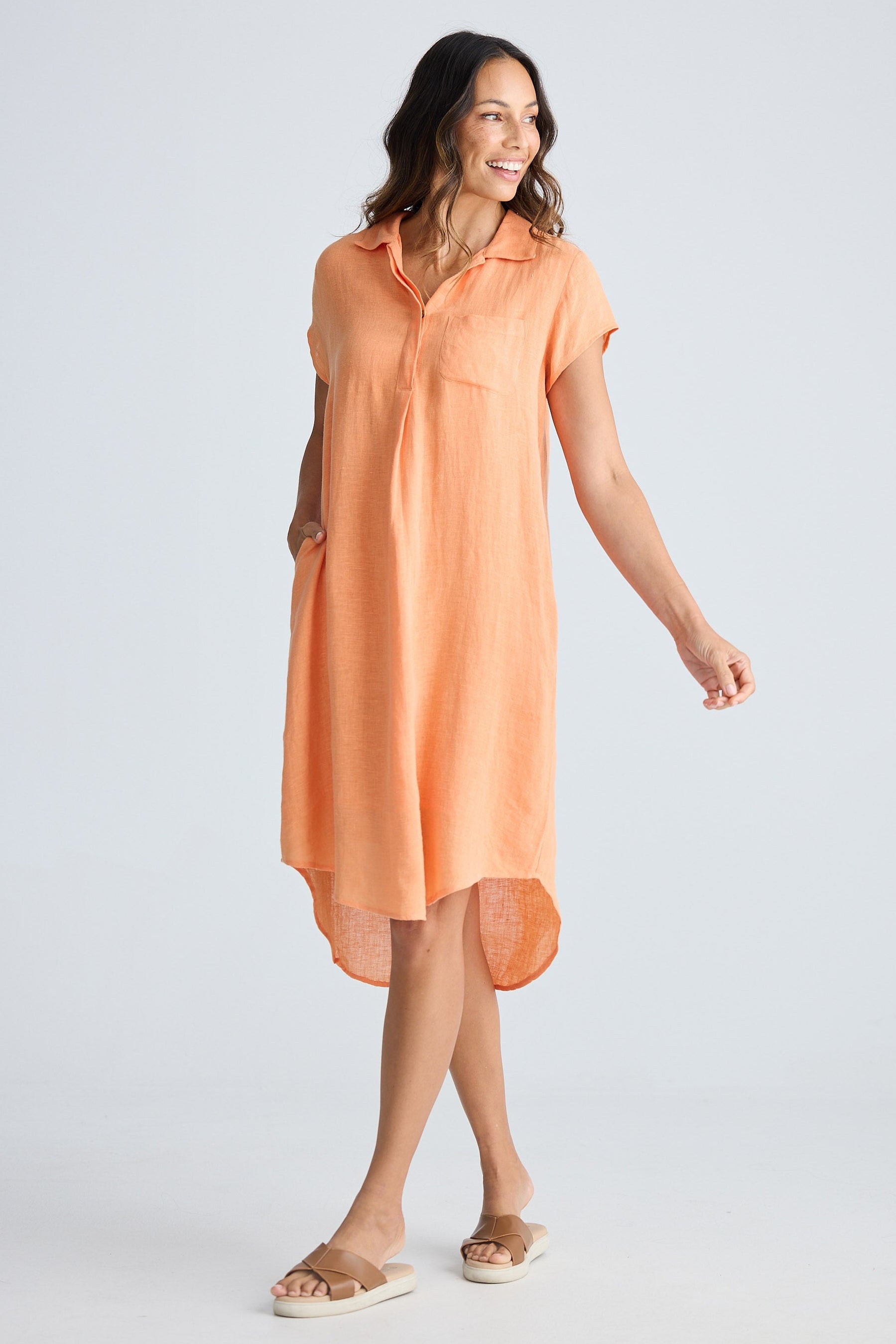Woman wearing an orange dress on a white background