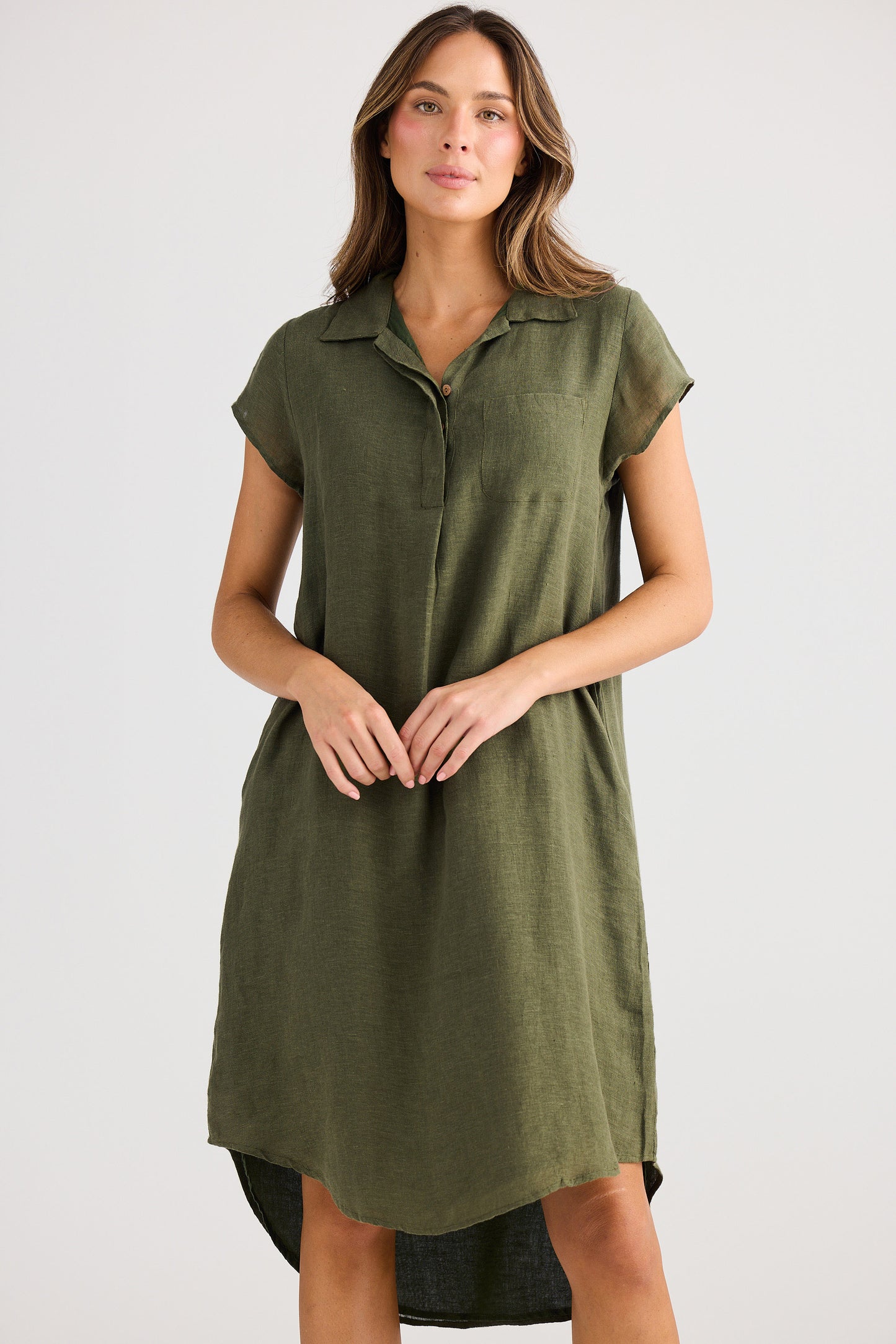 Woman wearing an olive green dress on a white background