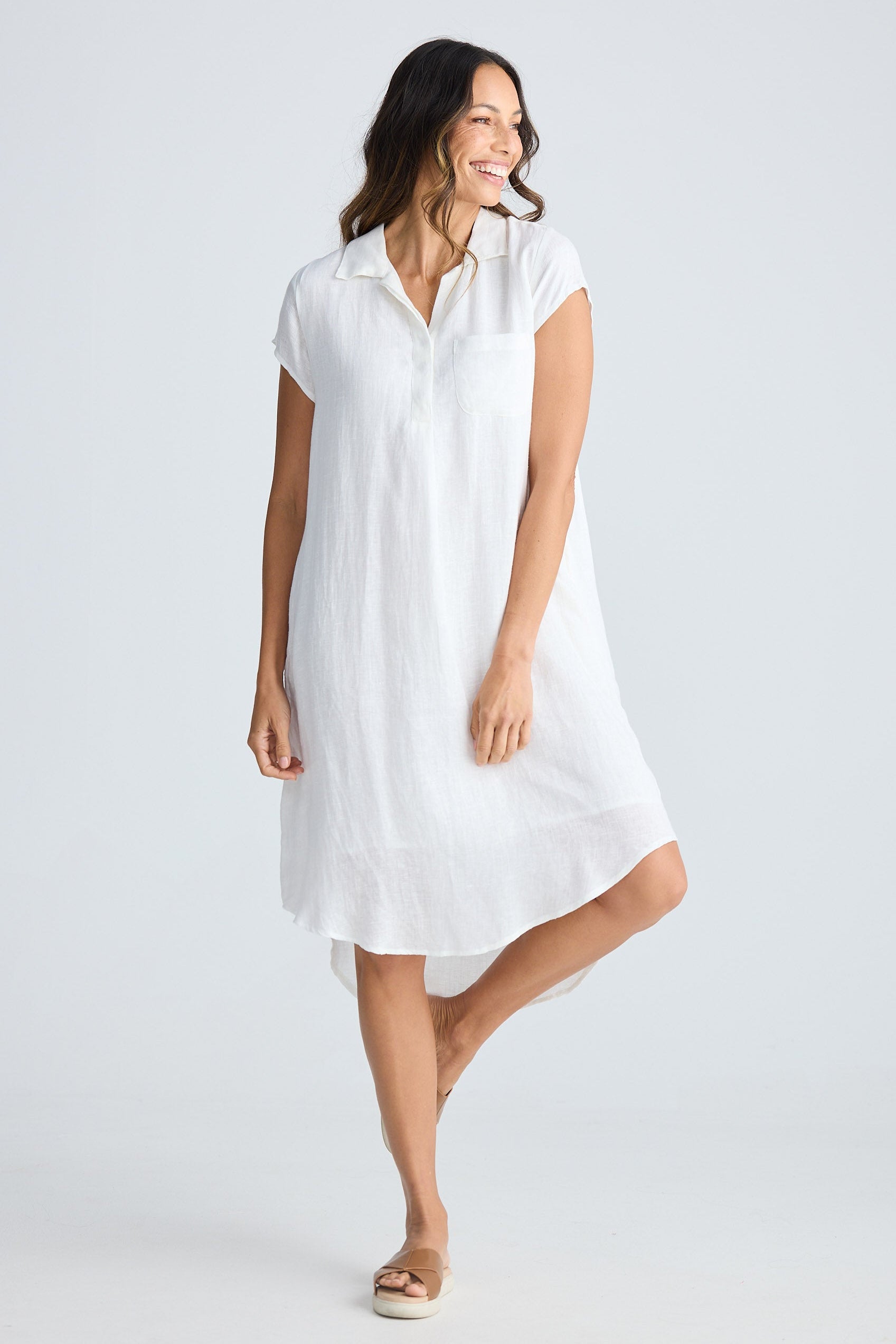 Woman wearing a white dress on a plain background