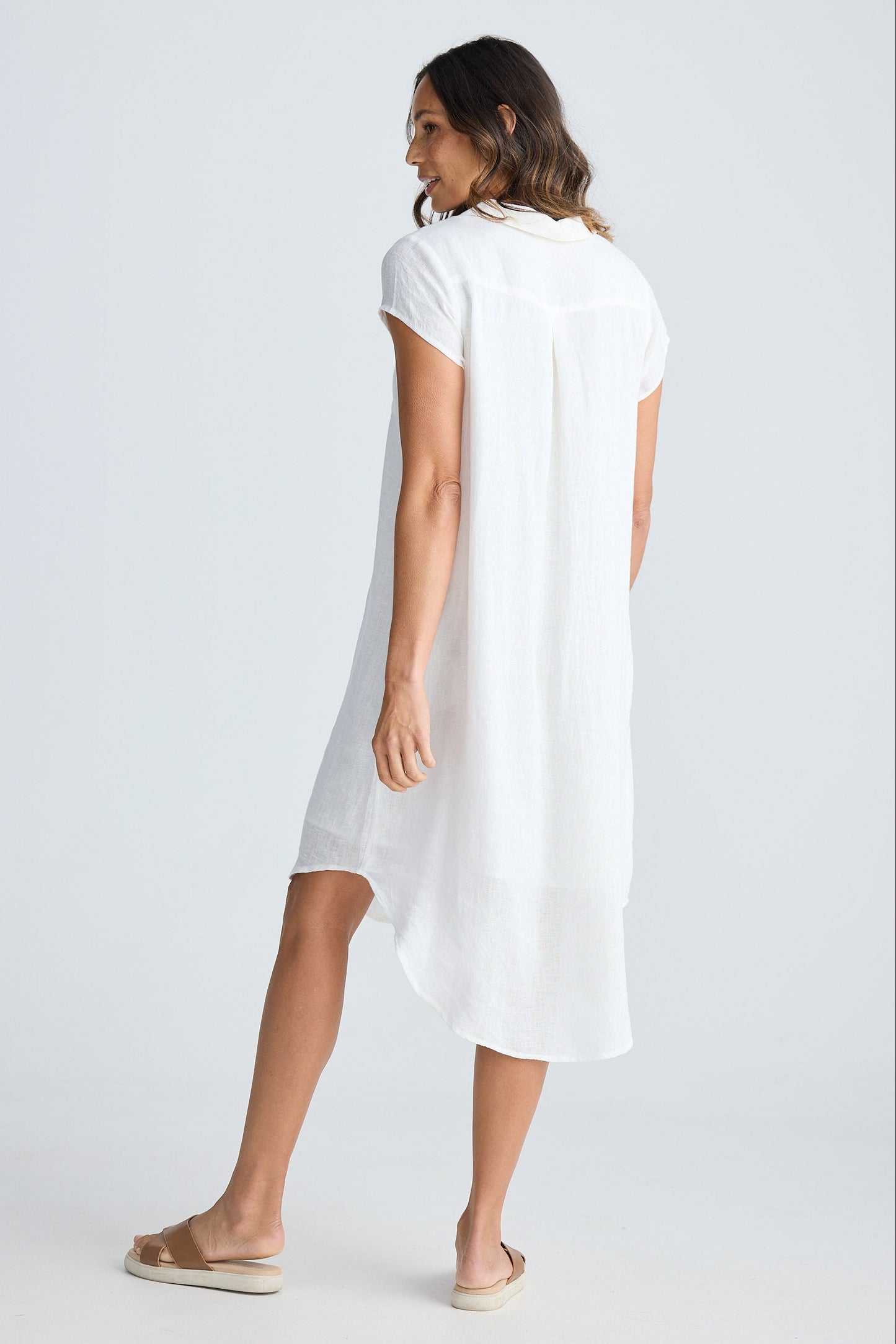 Woman wearing a white dress against a plain background