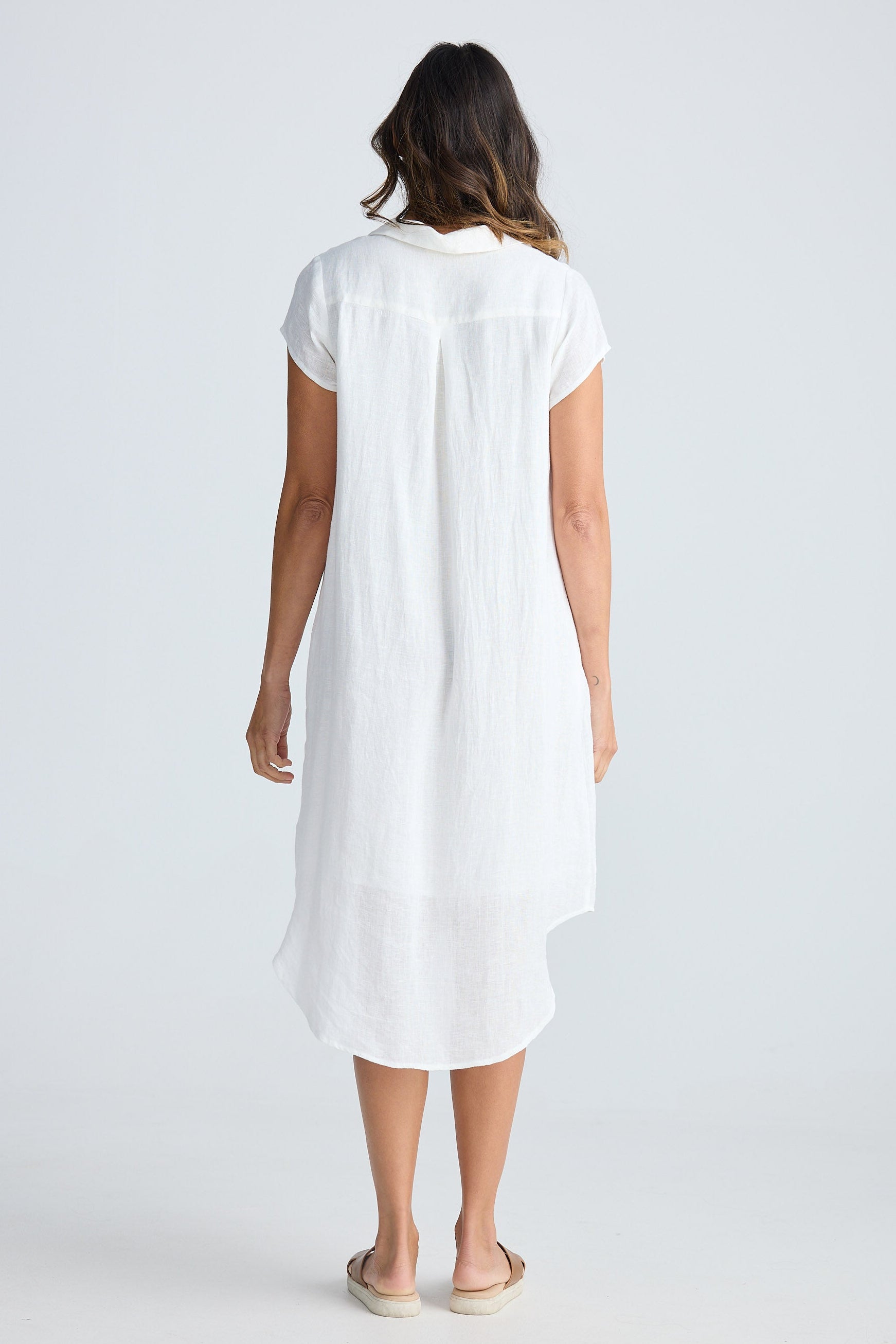 Woman wearing a white dress against a plain background