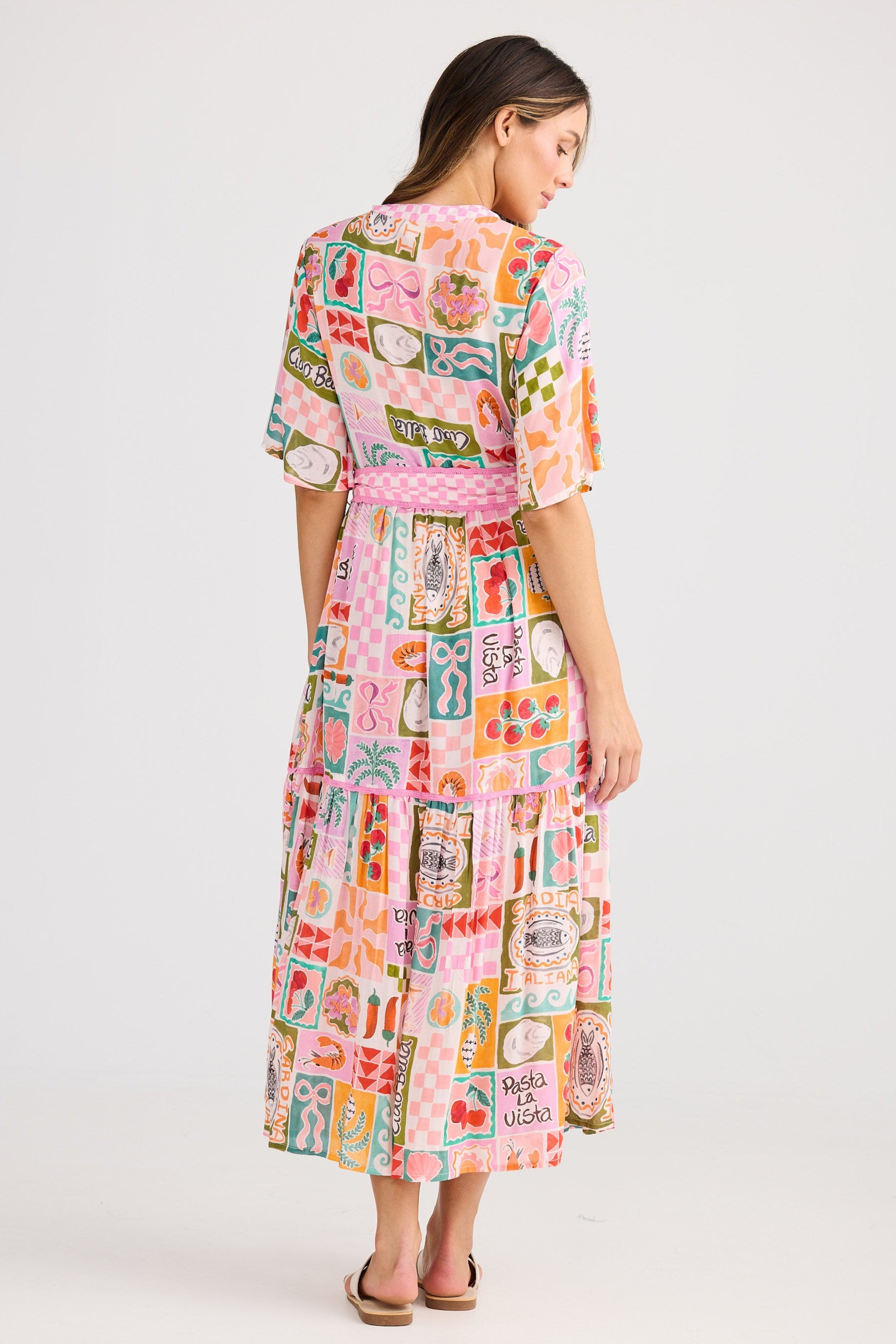 Woman wearing a colorful patterned dress on a white background