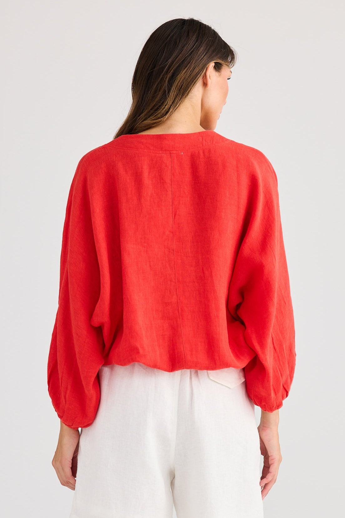 Person wearing a red top and white shorts on a plain background