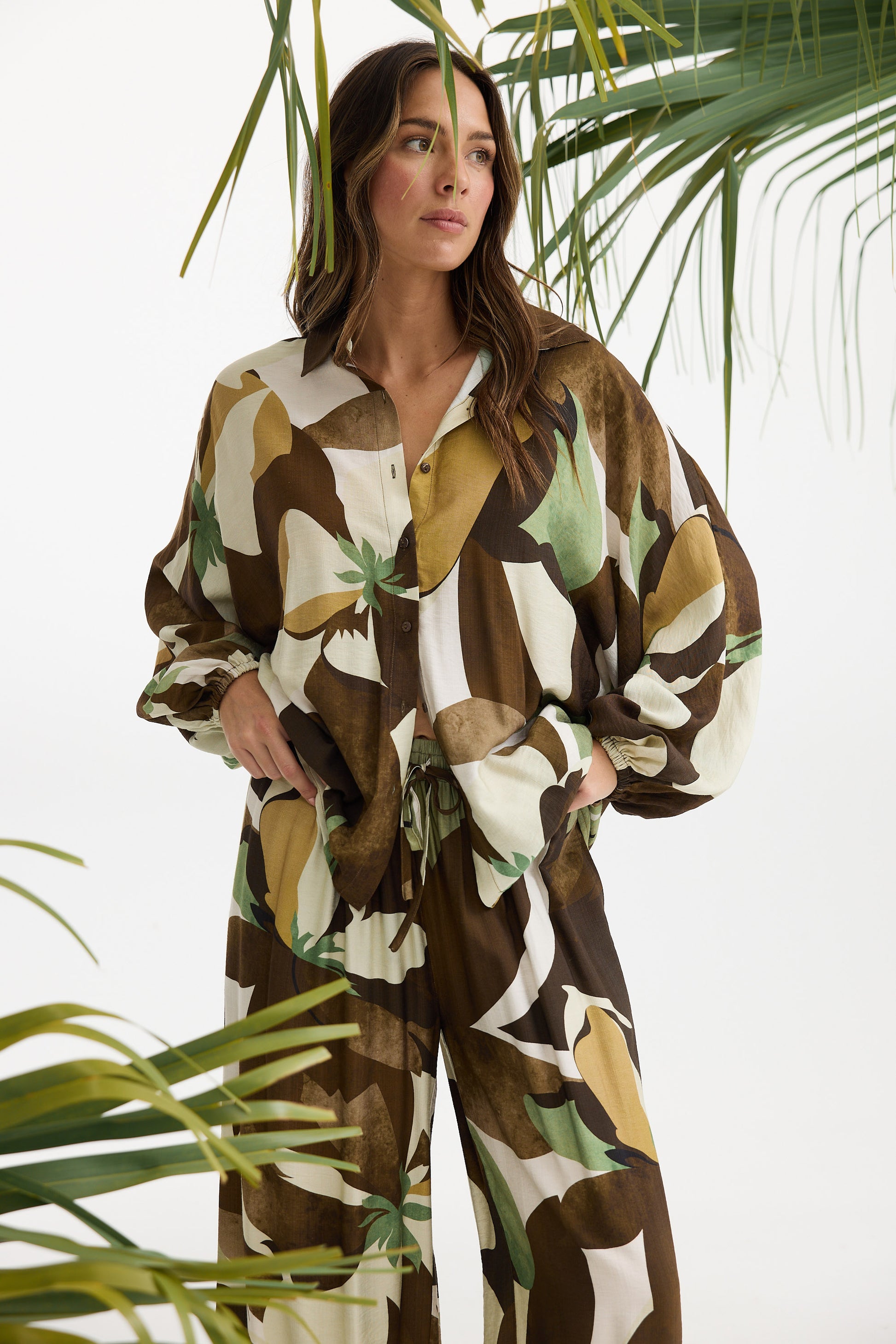 Woman wearing a patterned outfit with plants in the background