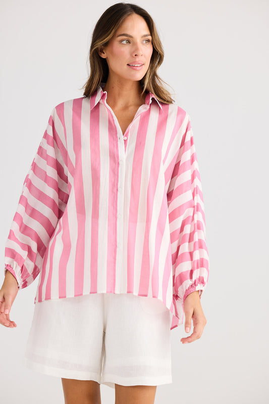 Woman wearing a pink and white striped shirt with a plain background