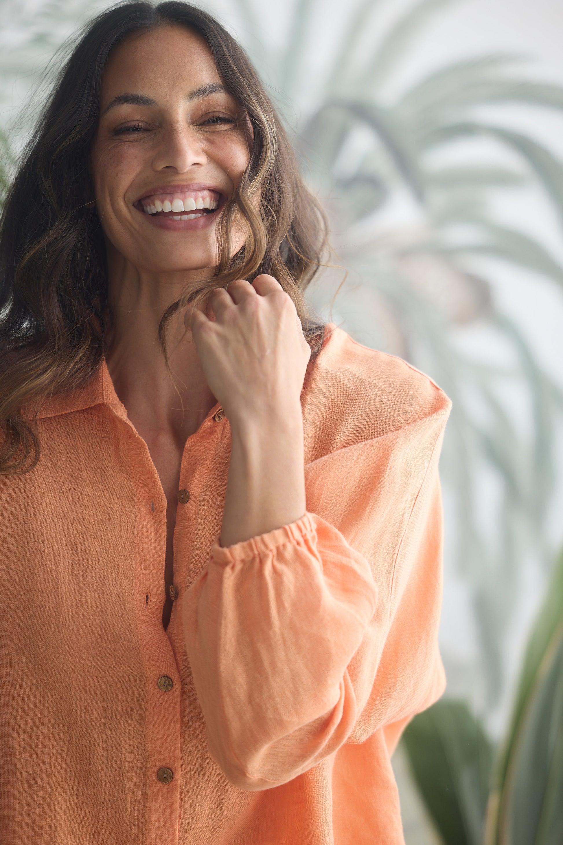 Woman wearing an orange shirt with a blurred background