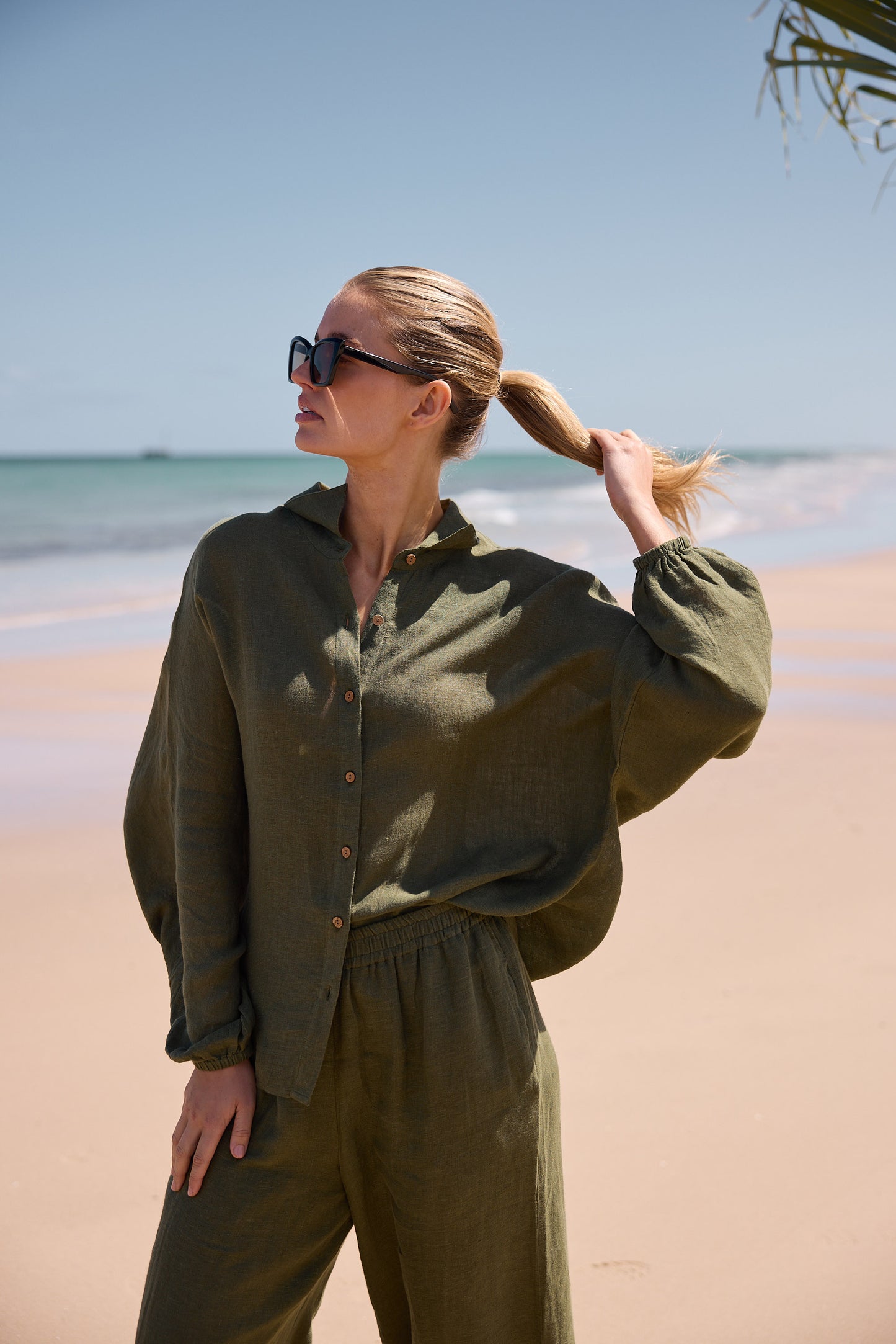 Woman in olive green outfit on a beach