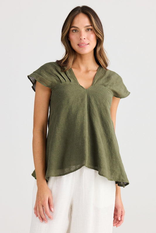 Woman wearing a green top with ruffled sleeves on a white background
