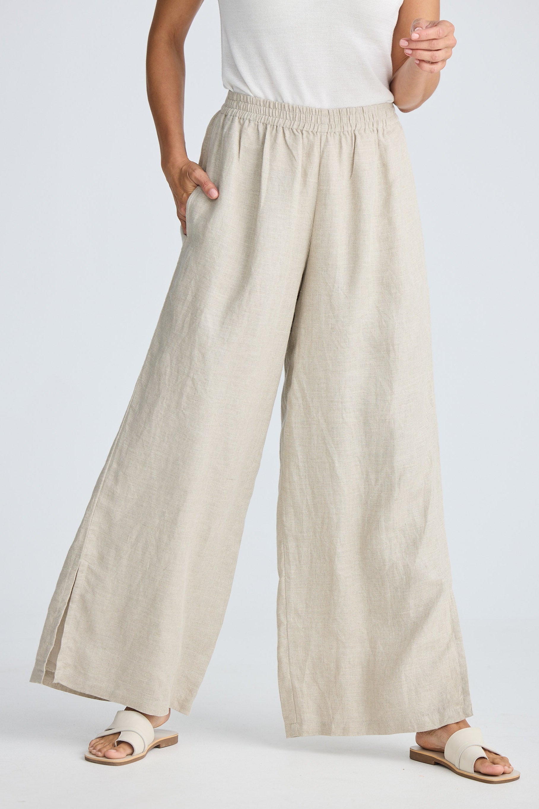 Person wearing beige wide-leg pants on a plain background