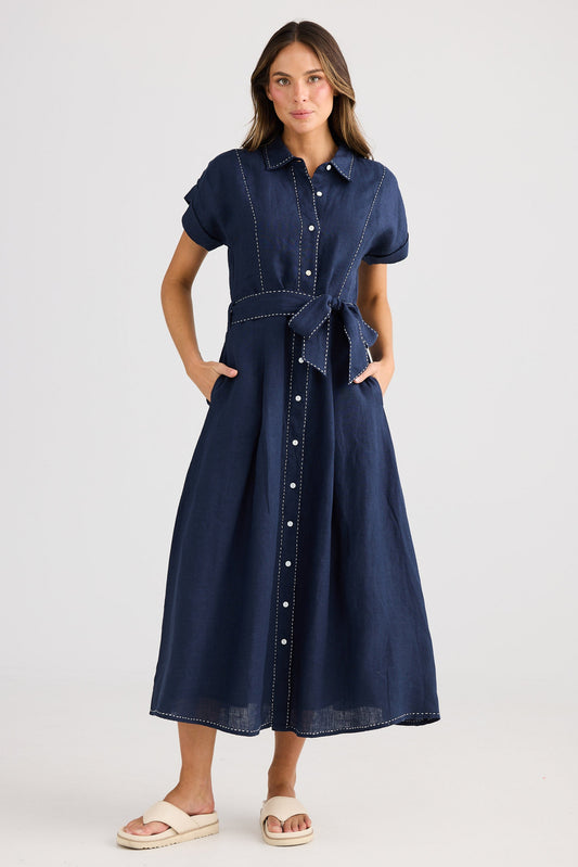 Woman wearing a navy denim dress on a white background