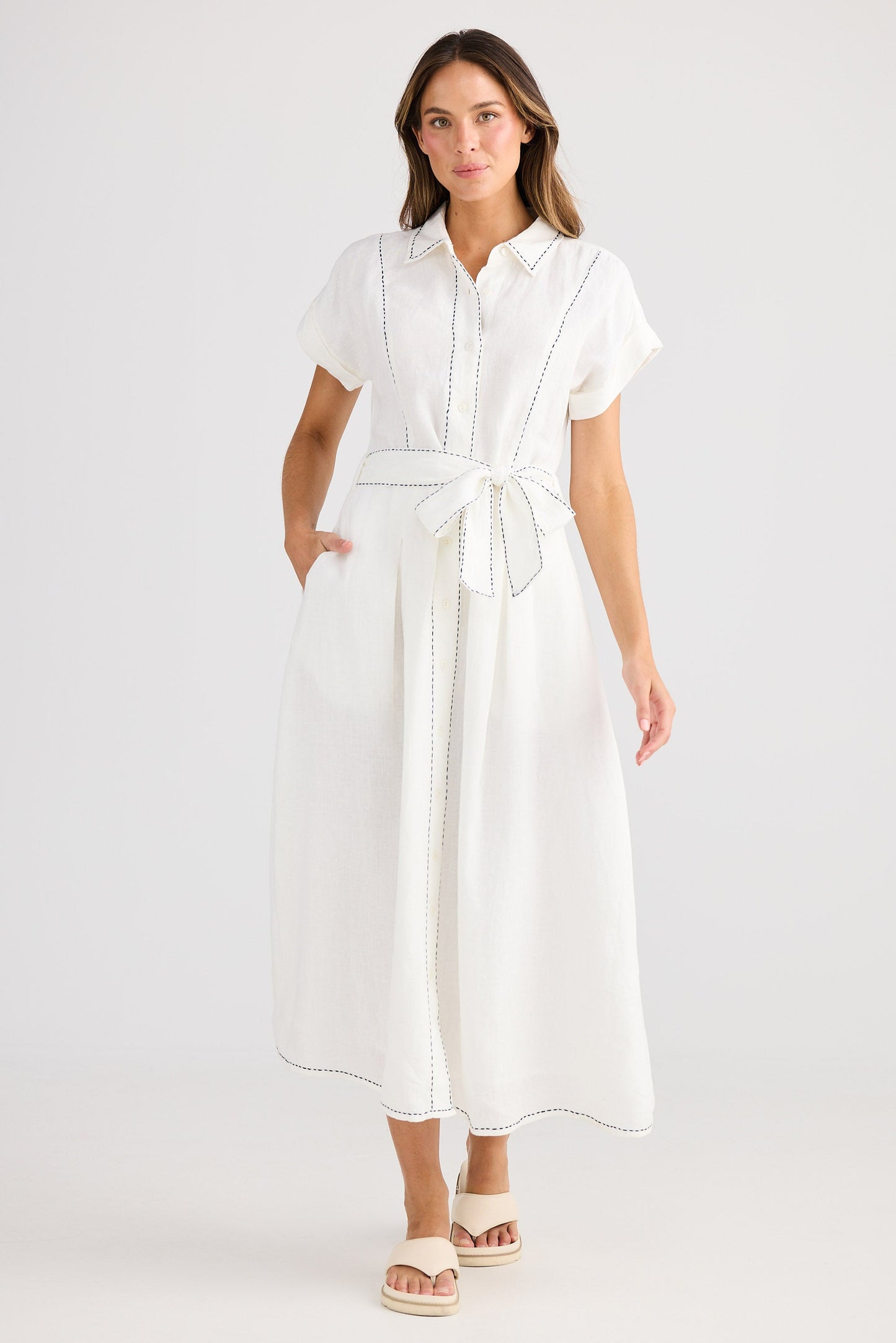 Woman wearing a white dress on a plain background