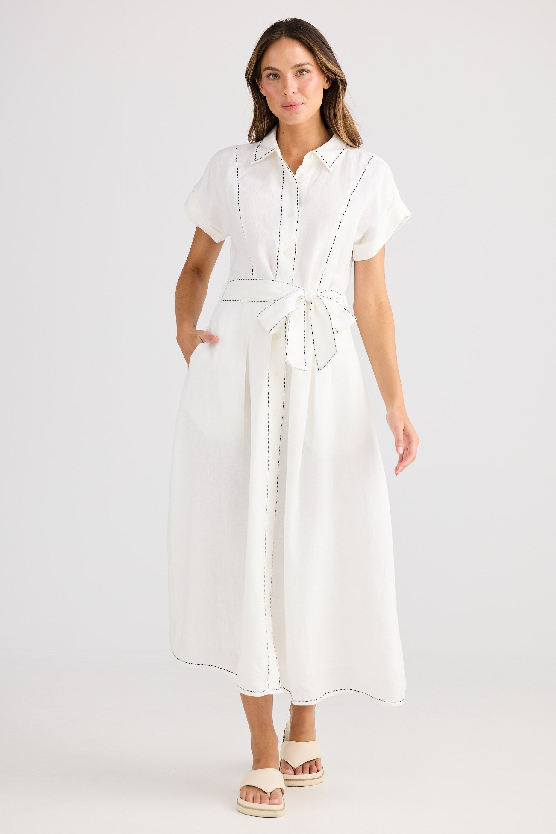 Woman wearing a white dress on a plain background