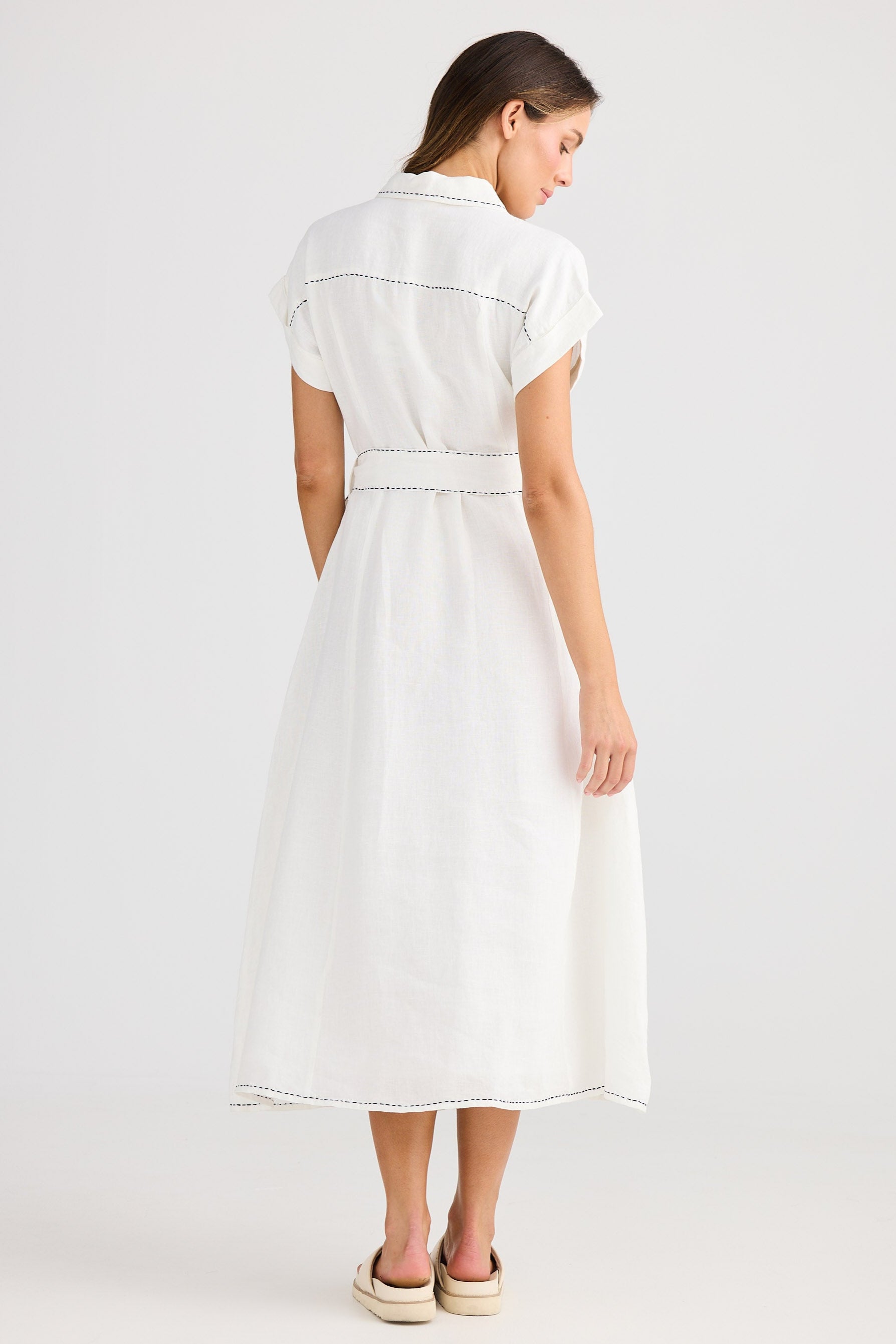 Woman wearing a white dress on a plain background