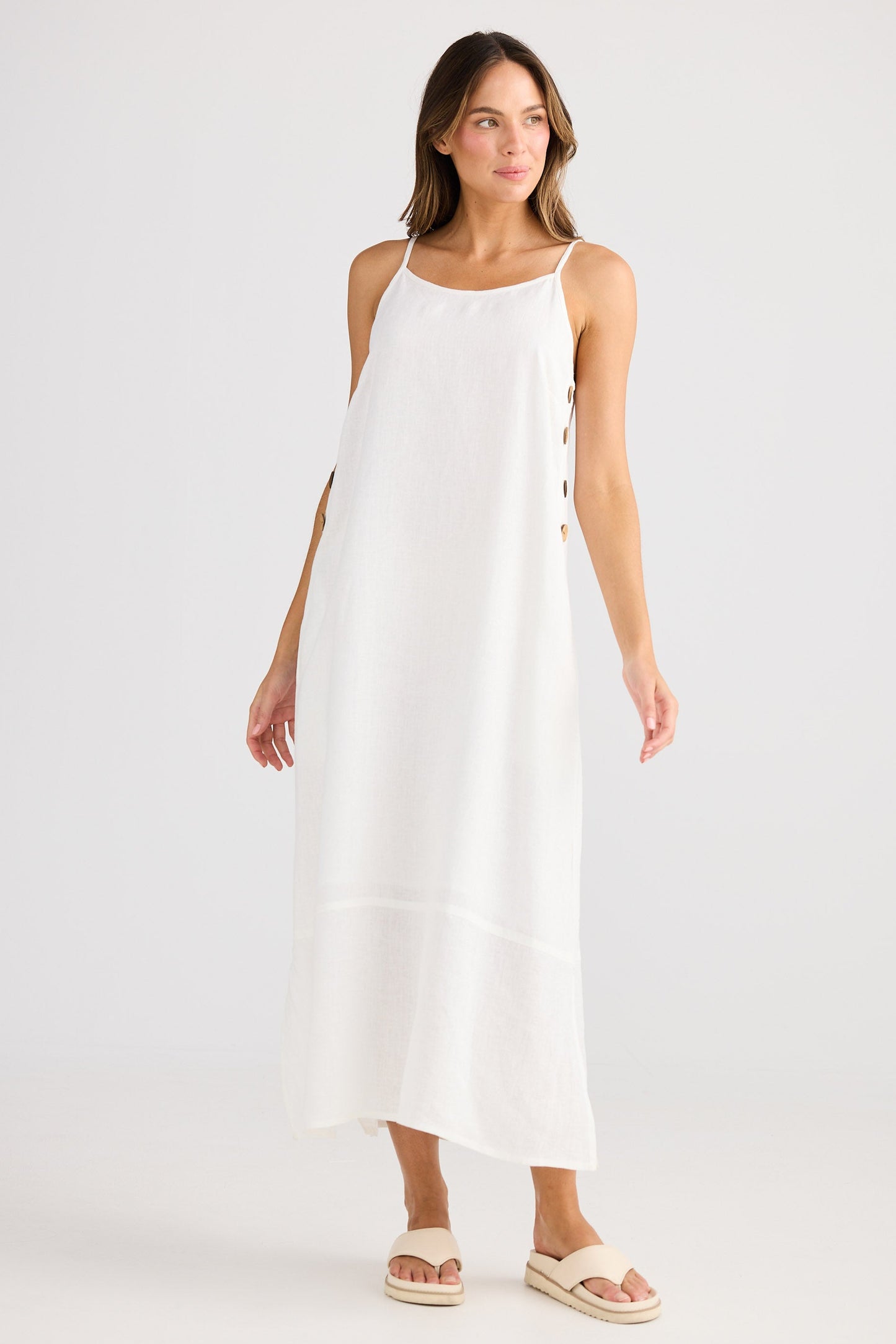 Woman wearing a white dress on a plain background