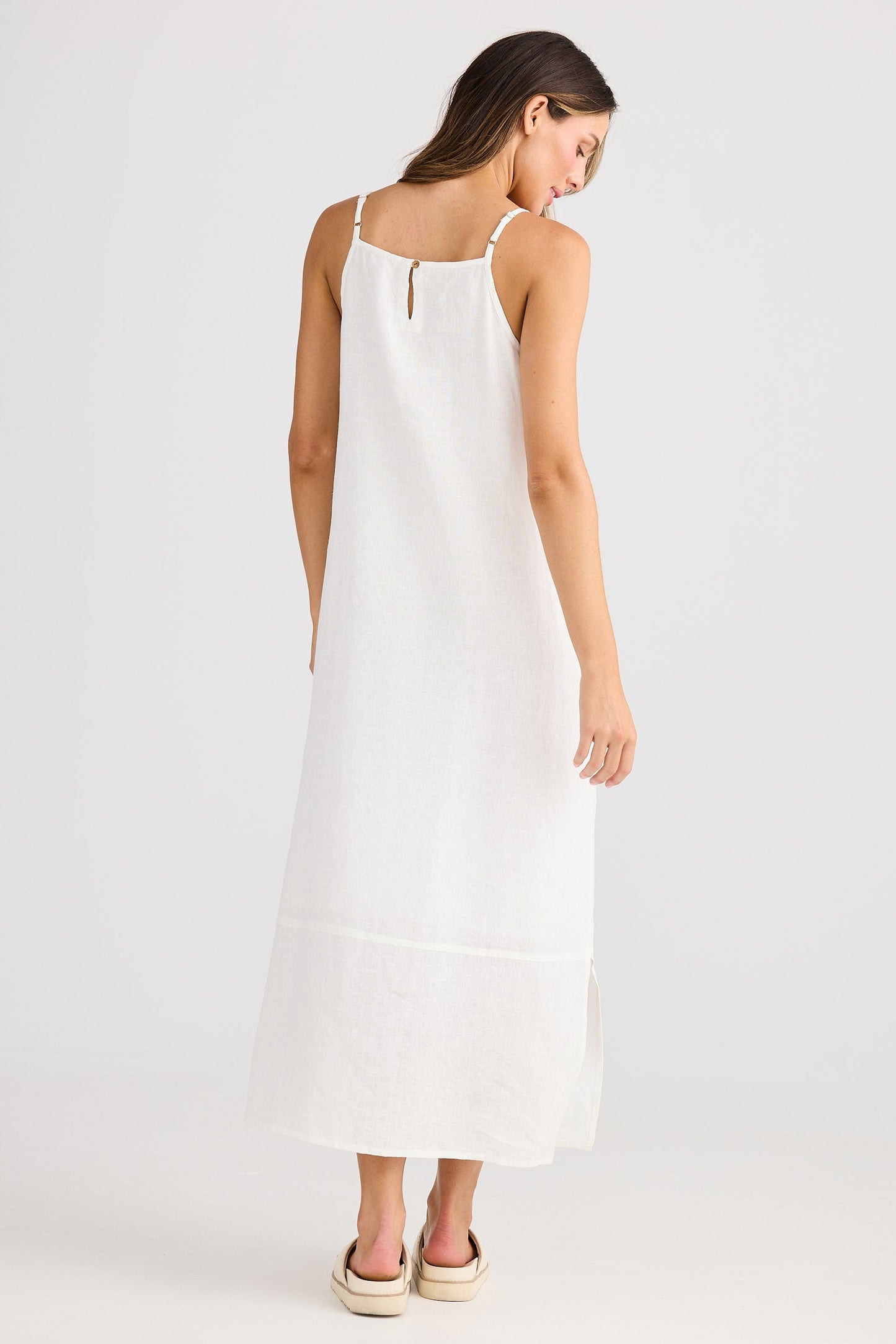 Woman wearing a white dress on a plain background