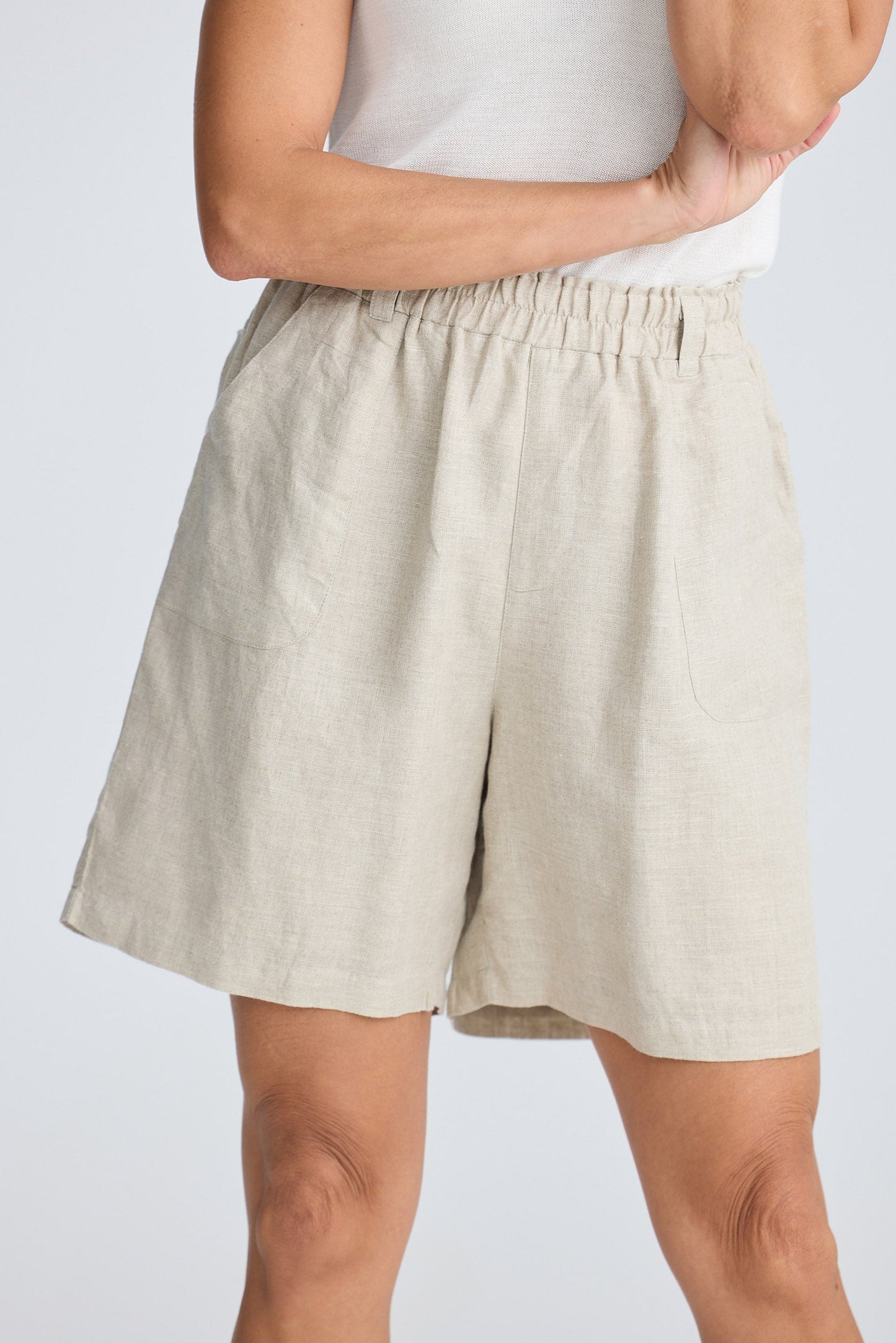 Beige shorts worn by a person on a plain background