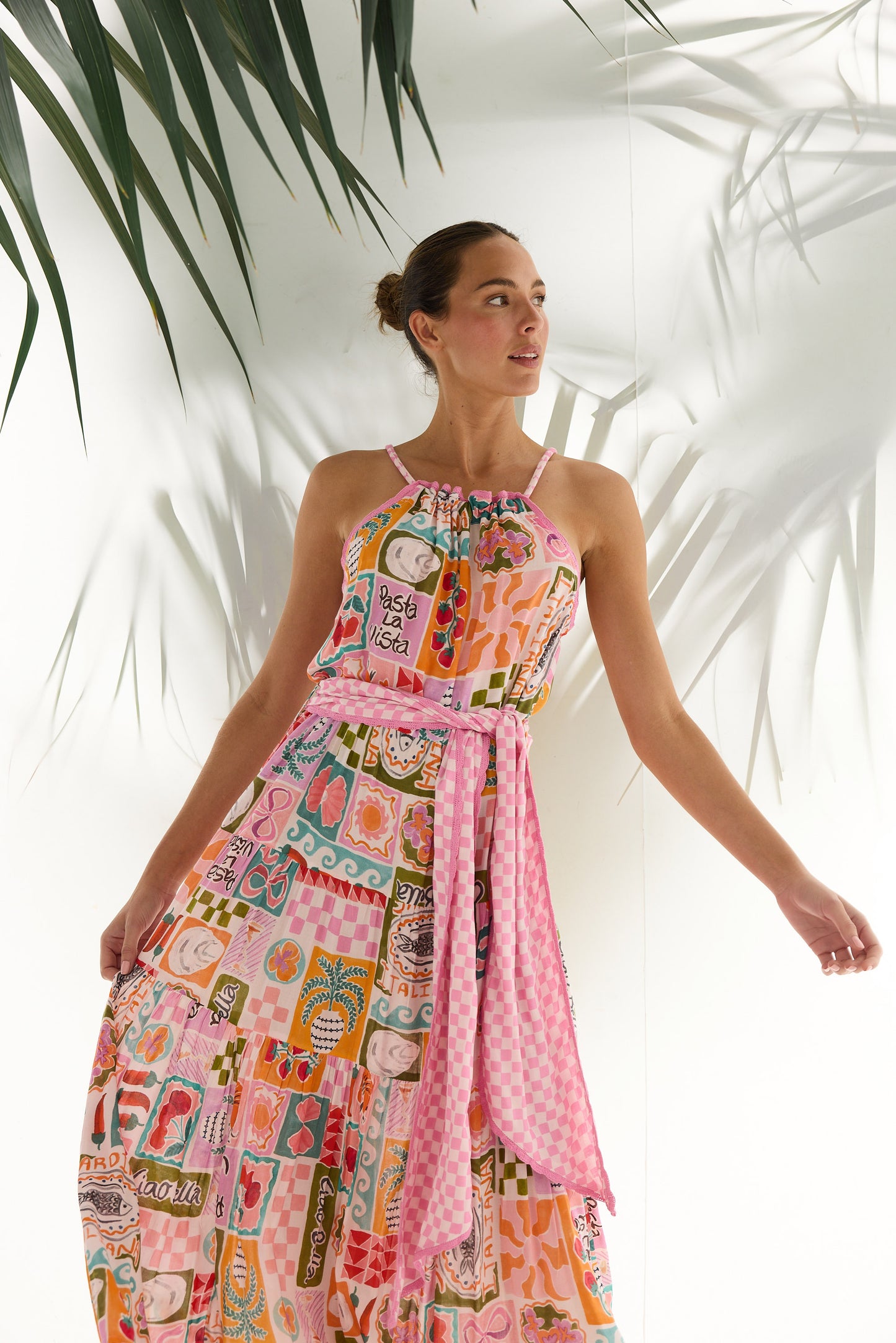 Woman wearing a colorful patterned dress with a white background