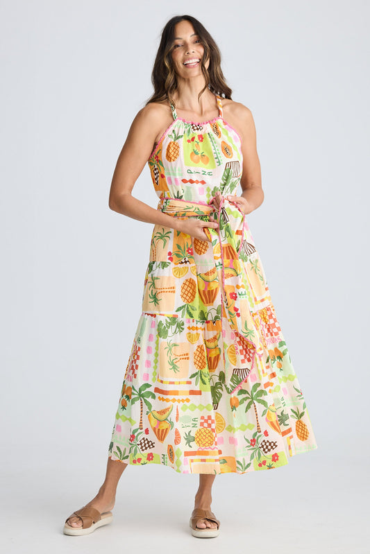 Woman wearing a colorful dress with pineapple pattern on a white background