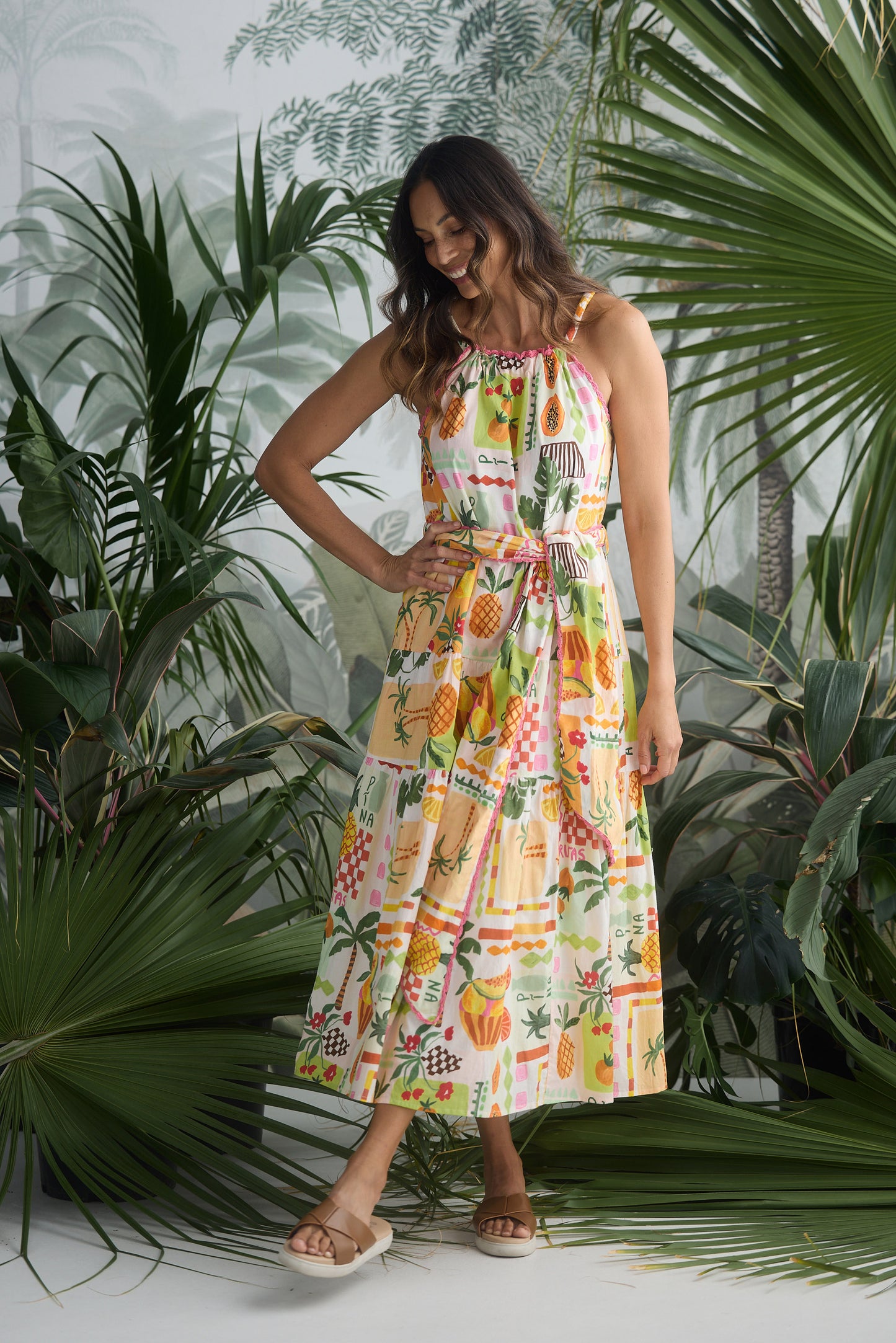 Woman in a colorful dress standing among tropical plants