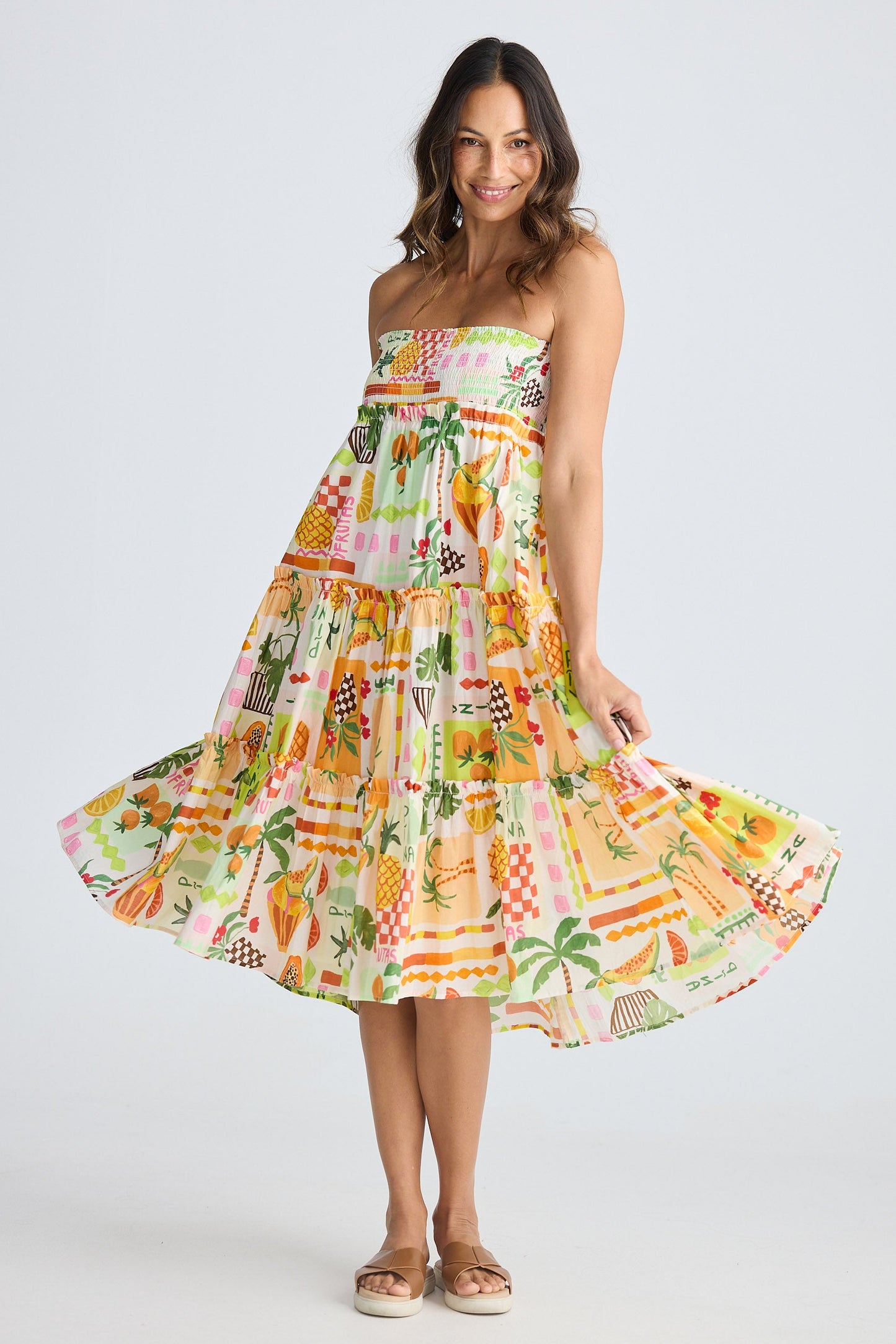 Woman wearing a colorful strapless dress with a pattern on a white background