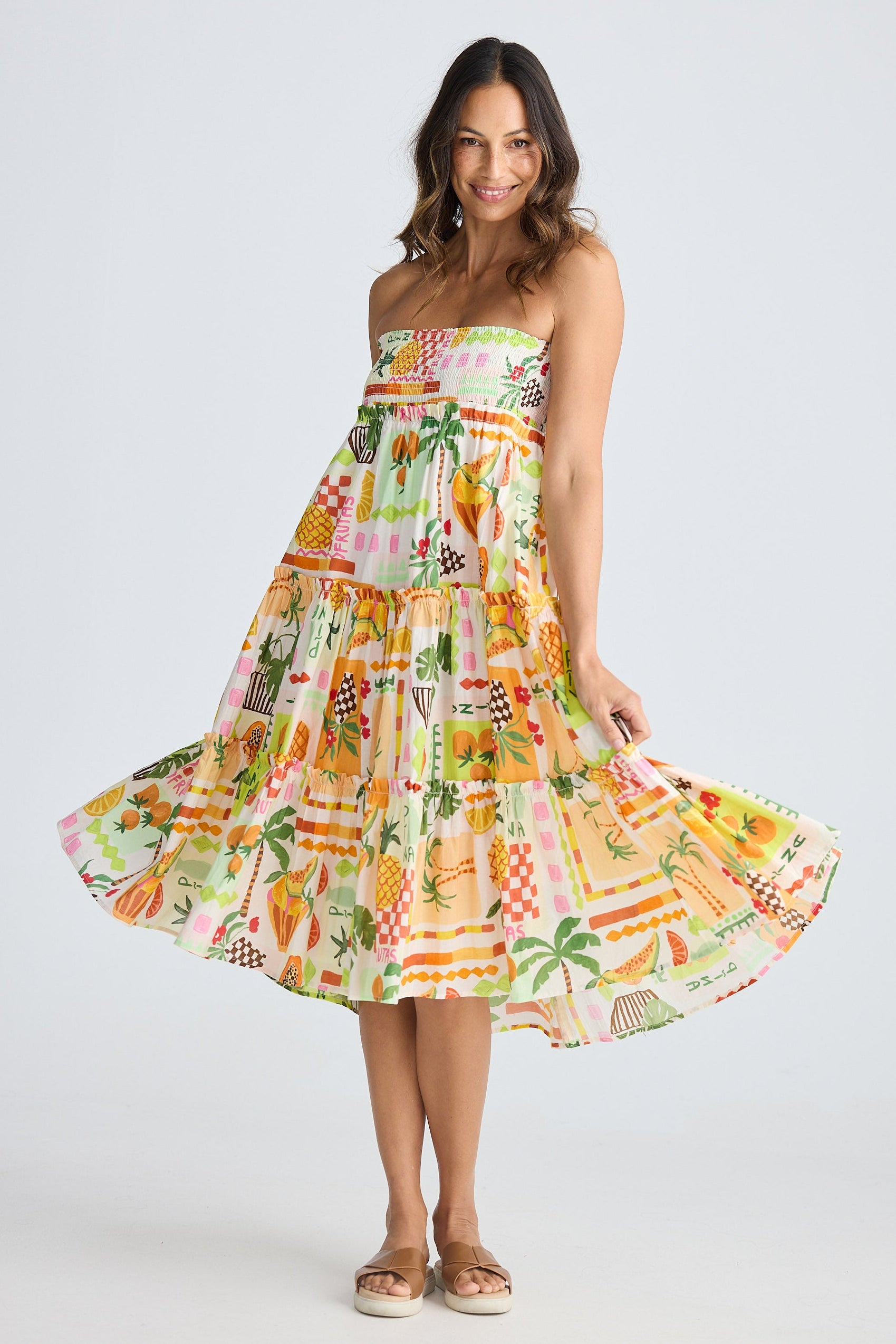 Woman wearing a colorful strapless dress with a pattern on a white background