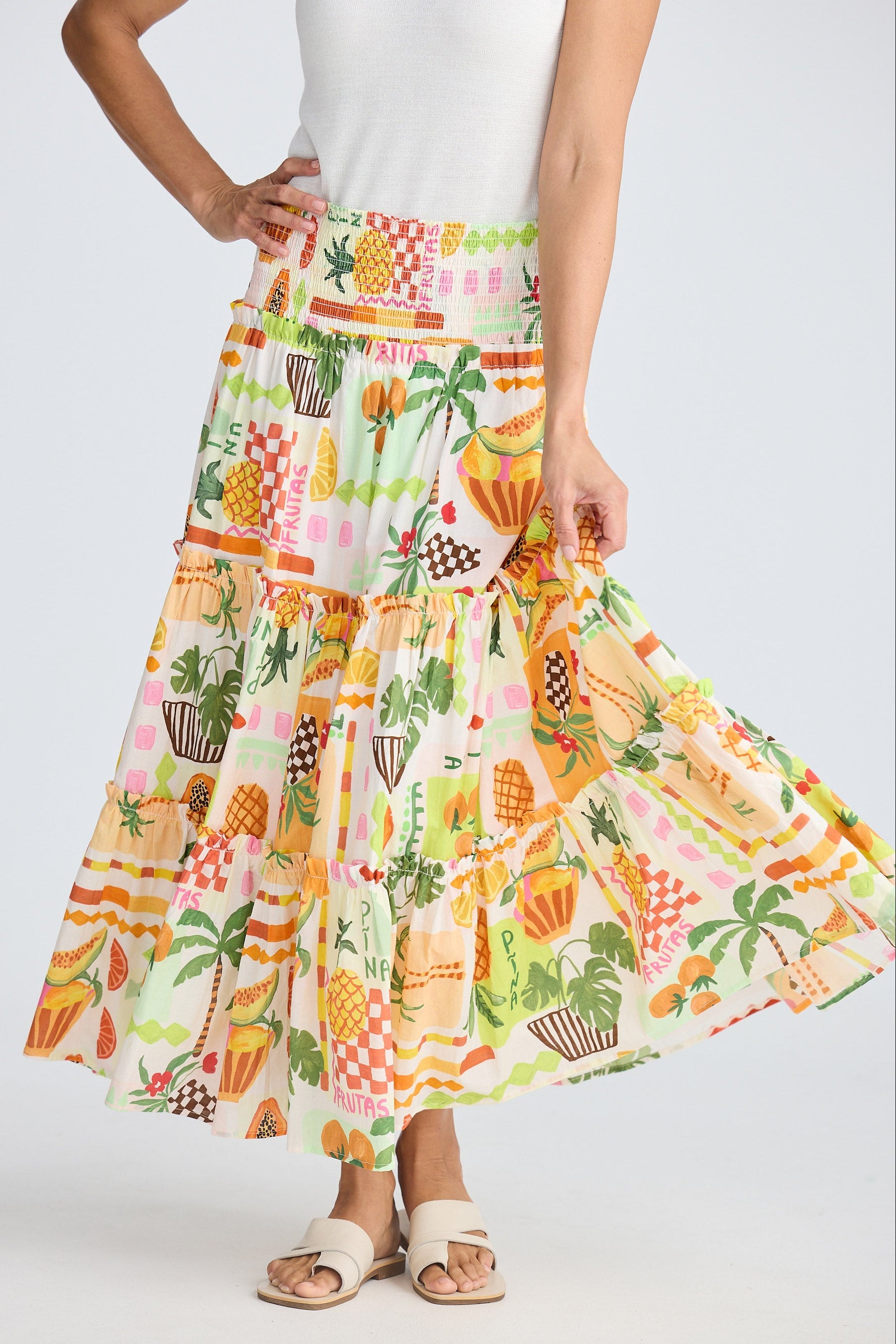 Woman wearing a colorful tropical print skirt on a white background