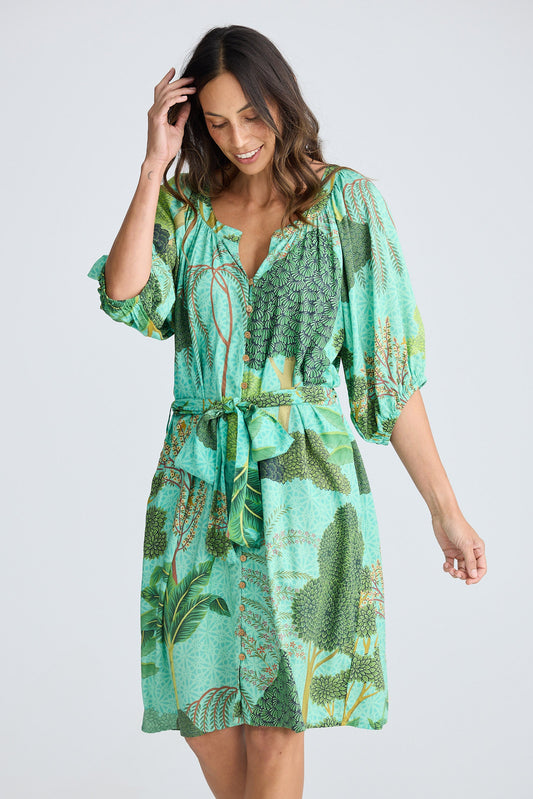 Woman wearing a green patterned dress on a white background