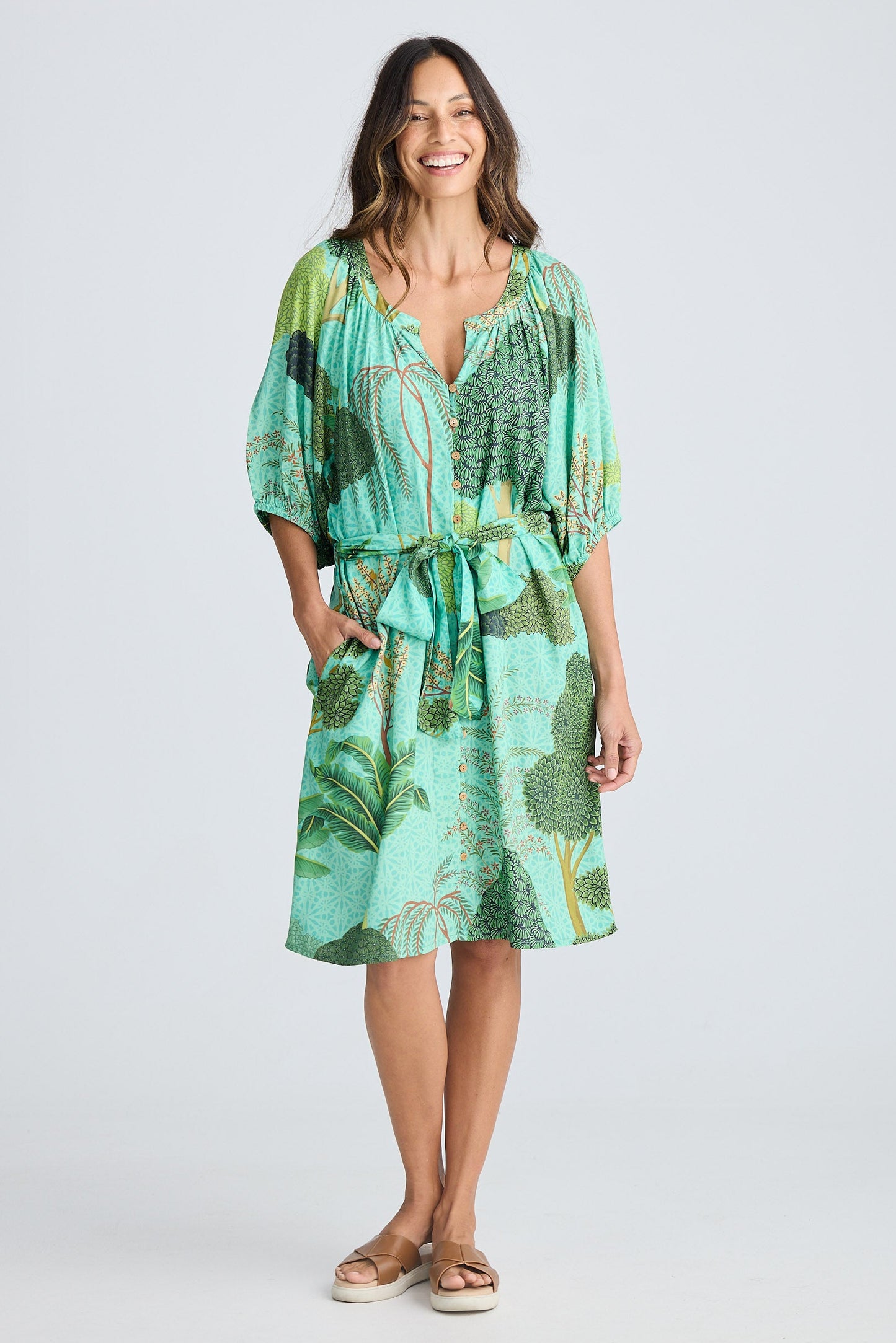 Woman wearing a green patterned dress on a white background