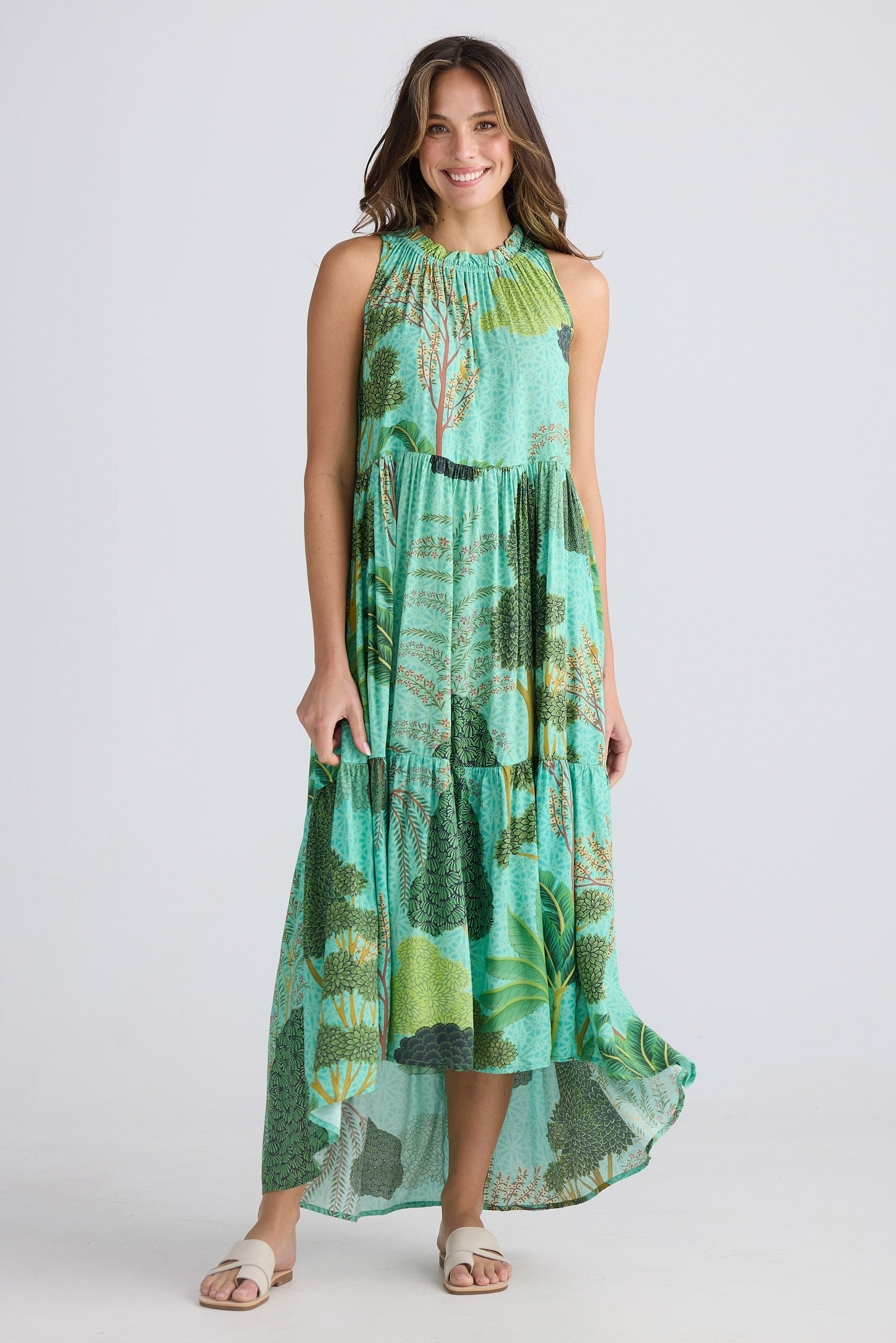 Woman wearing a green and blue patterned dress on a white background