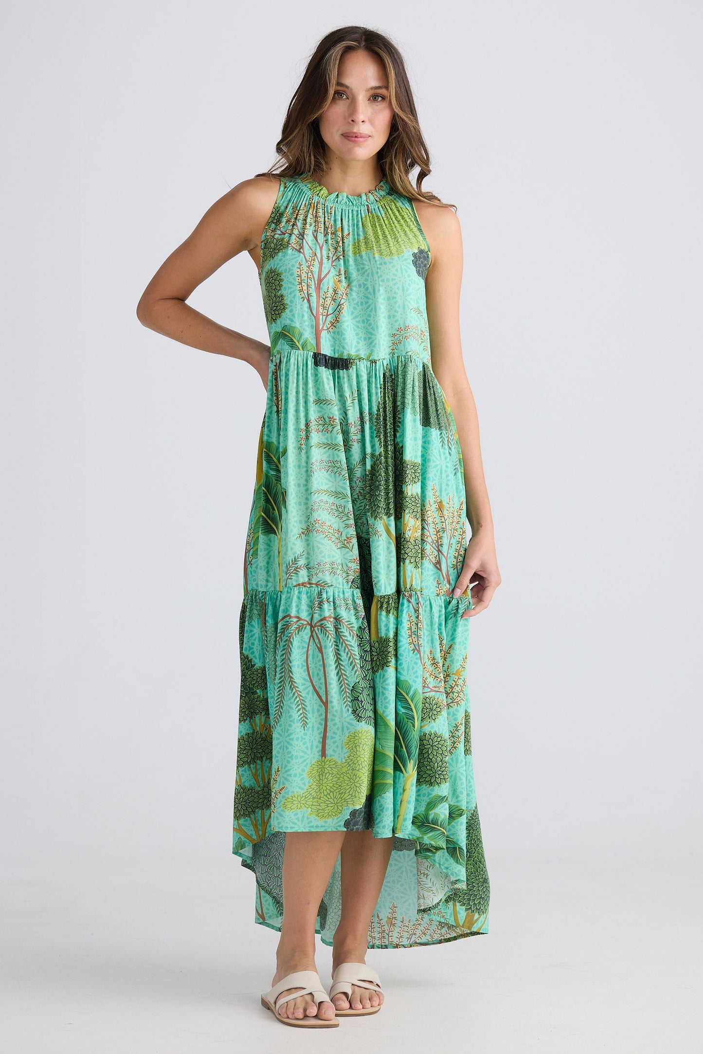 Woman wearing a green patterned dress on a white background