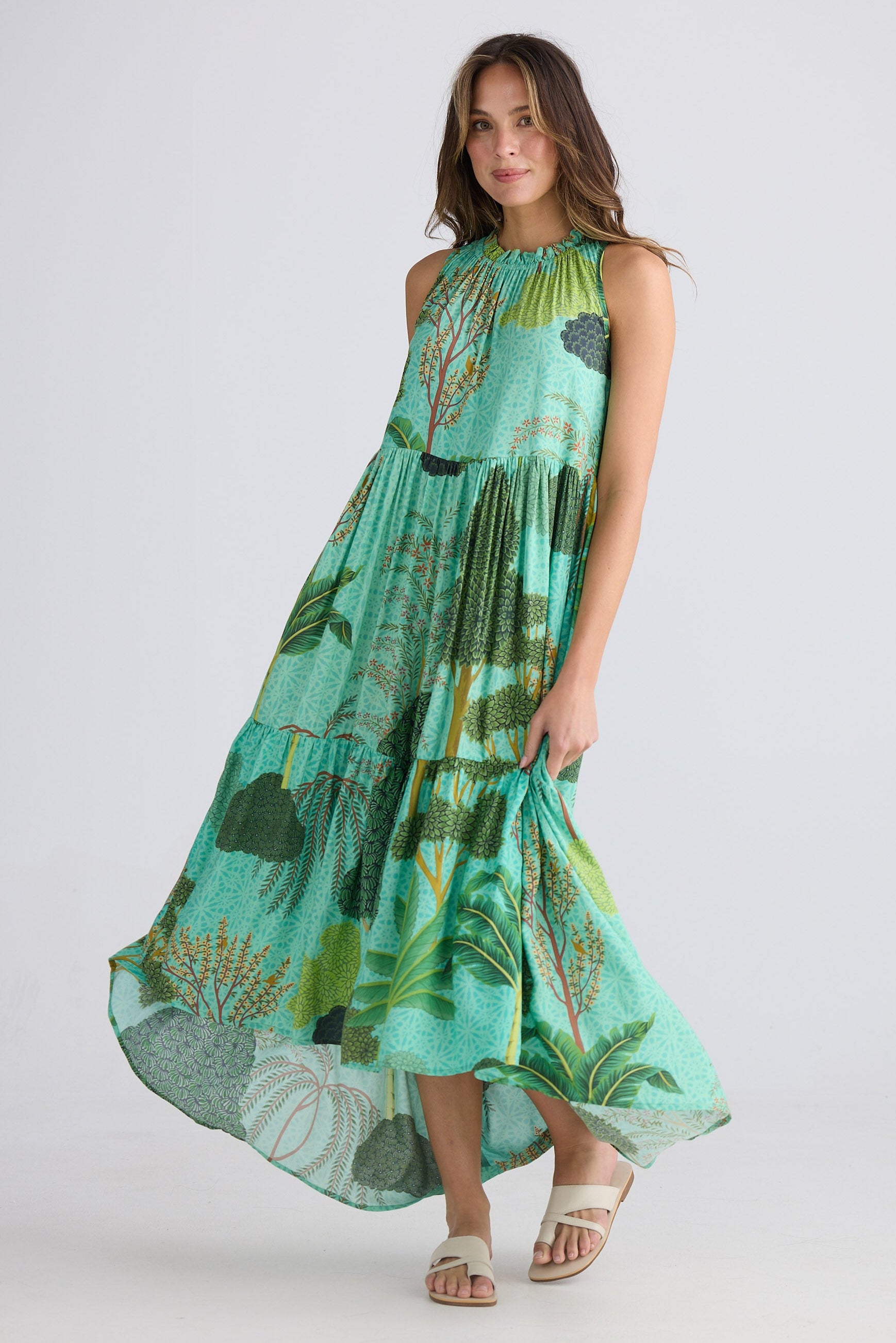 Woman wearing a green patterned dress on a white background