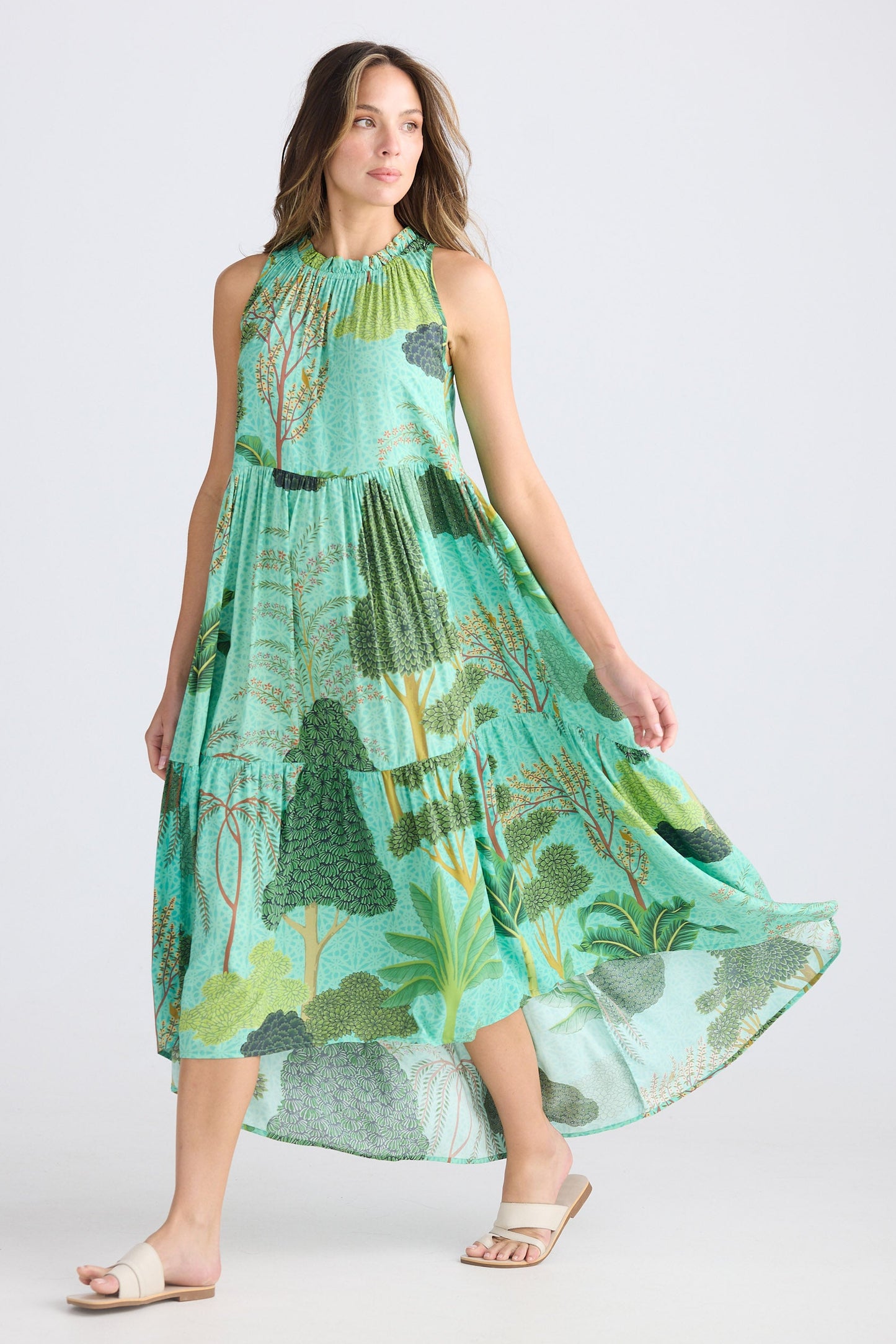 Woman wearing a green floral dress on a white background