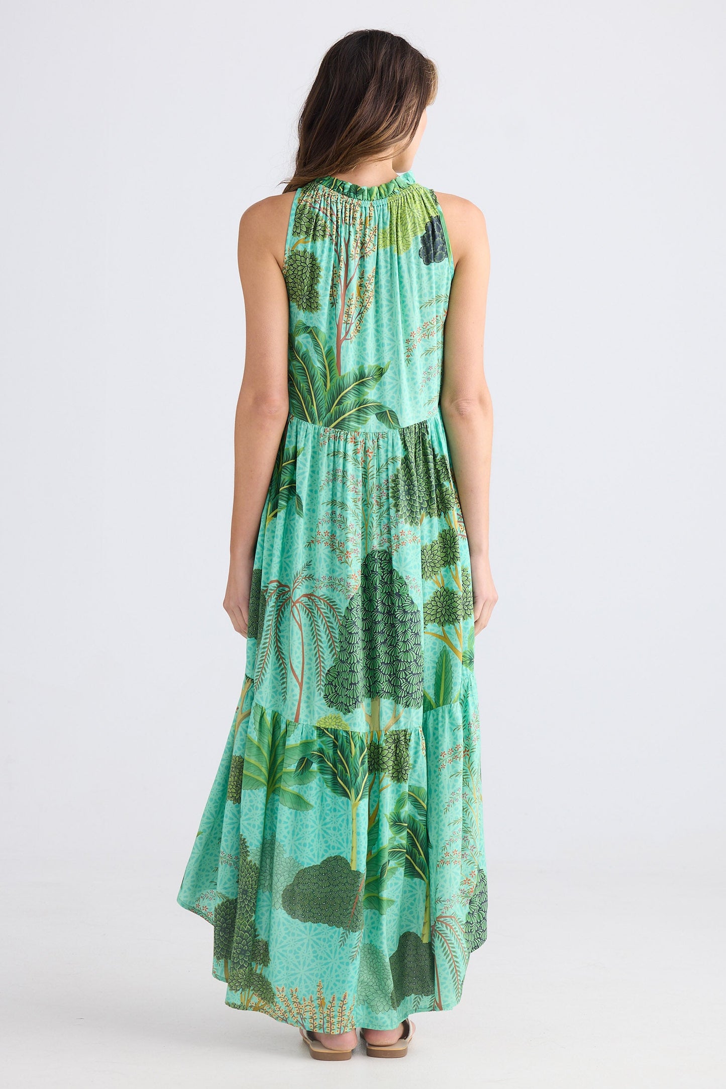 Woman wearing a green floral dress on a white background