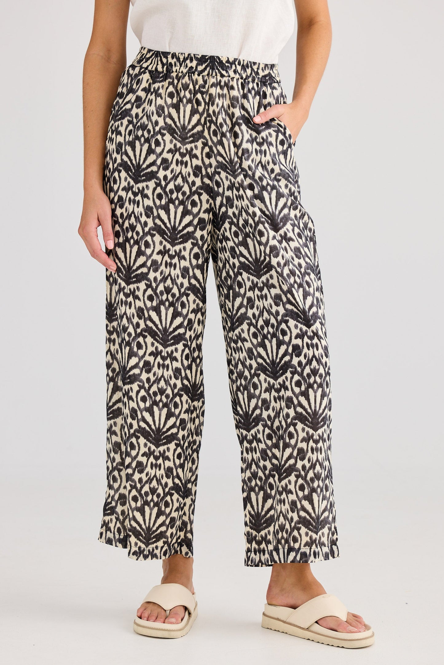 Person wearing patterned pants on a plain background