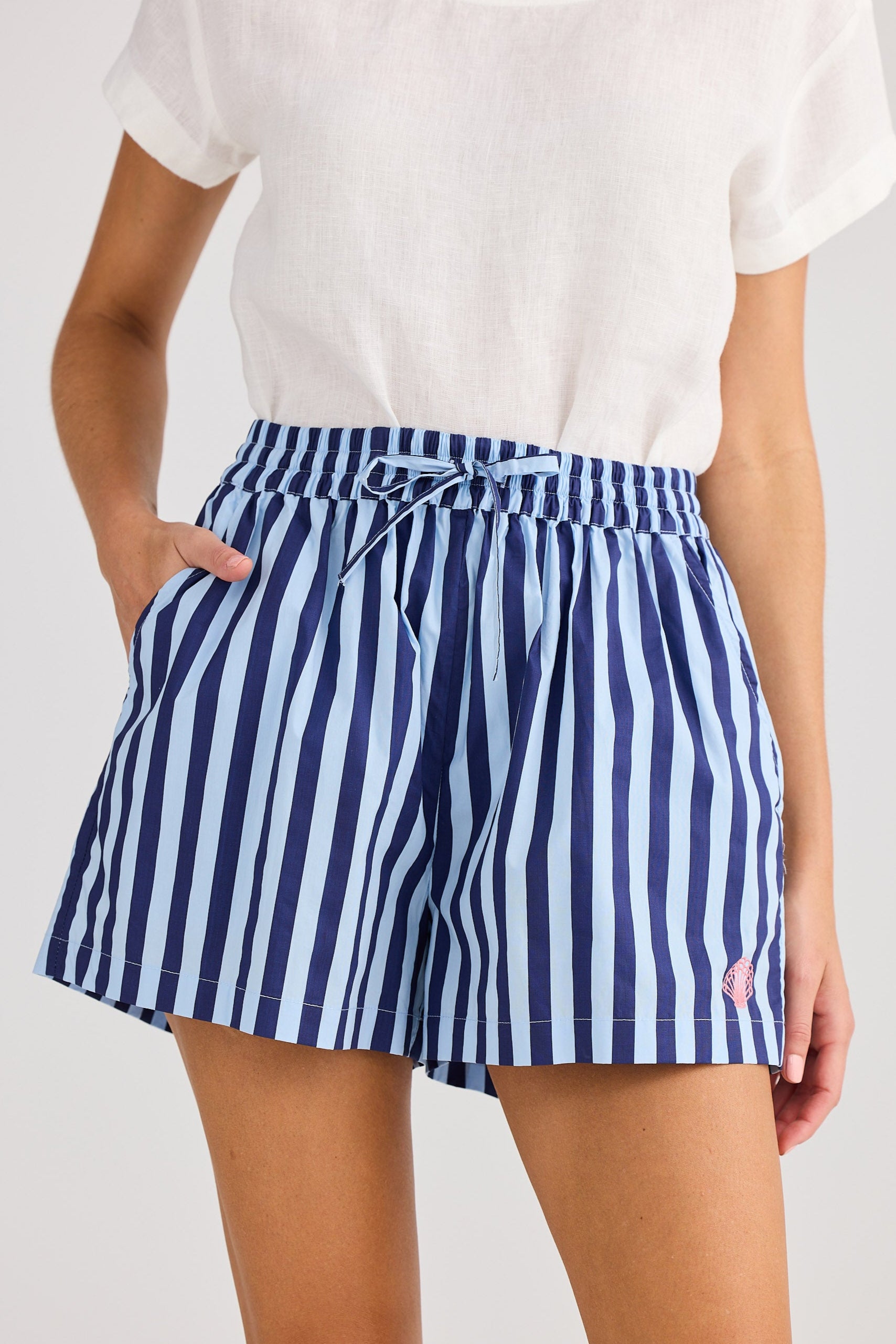 Person wearing blue and white striped shorts on a plain background